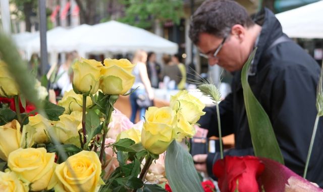 Roses grogues a una parada de Rambla Catalunya de Barcelona, amb un comprador de fons | A. Zamorano (ACN) 