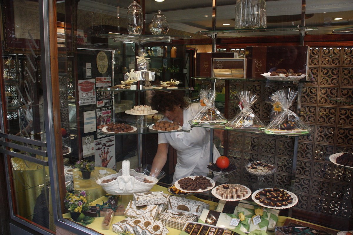 La propietària de la Pastisseria Cosp, Susana Cosp, arreglant l'aparador del seu comerç