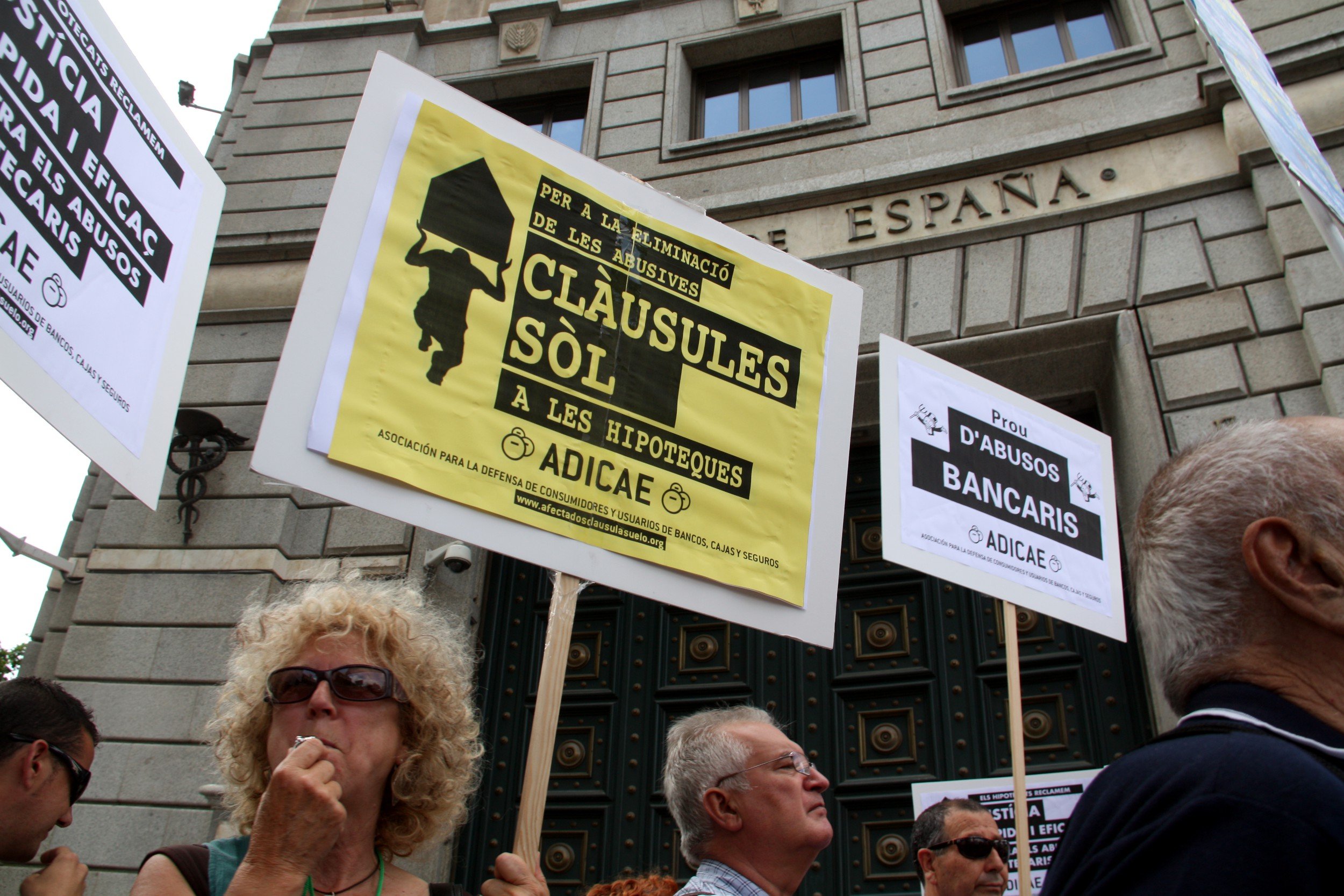 Una mujer con una pancarta en contra las cláusulas suelo ante la sede del Banco de España