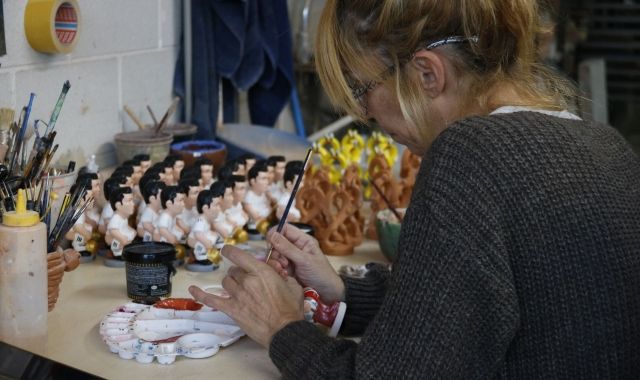 Una dona pintant un dels caganers del Caganer.com