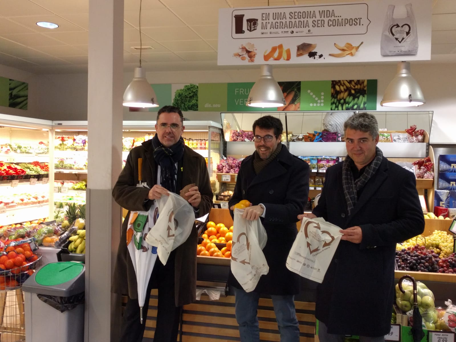 Tost, Batalla i Mateu mostrant les bosses compostables que reparteixen els comerços | Cedida