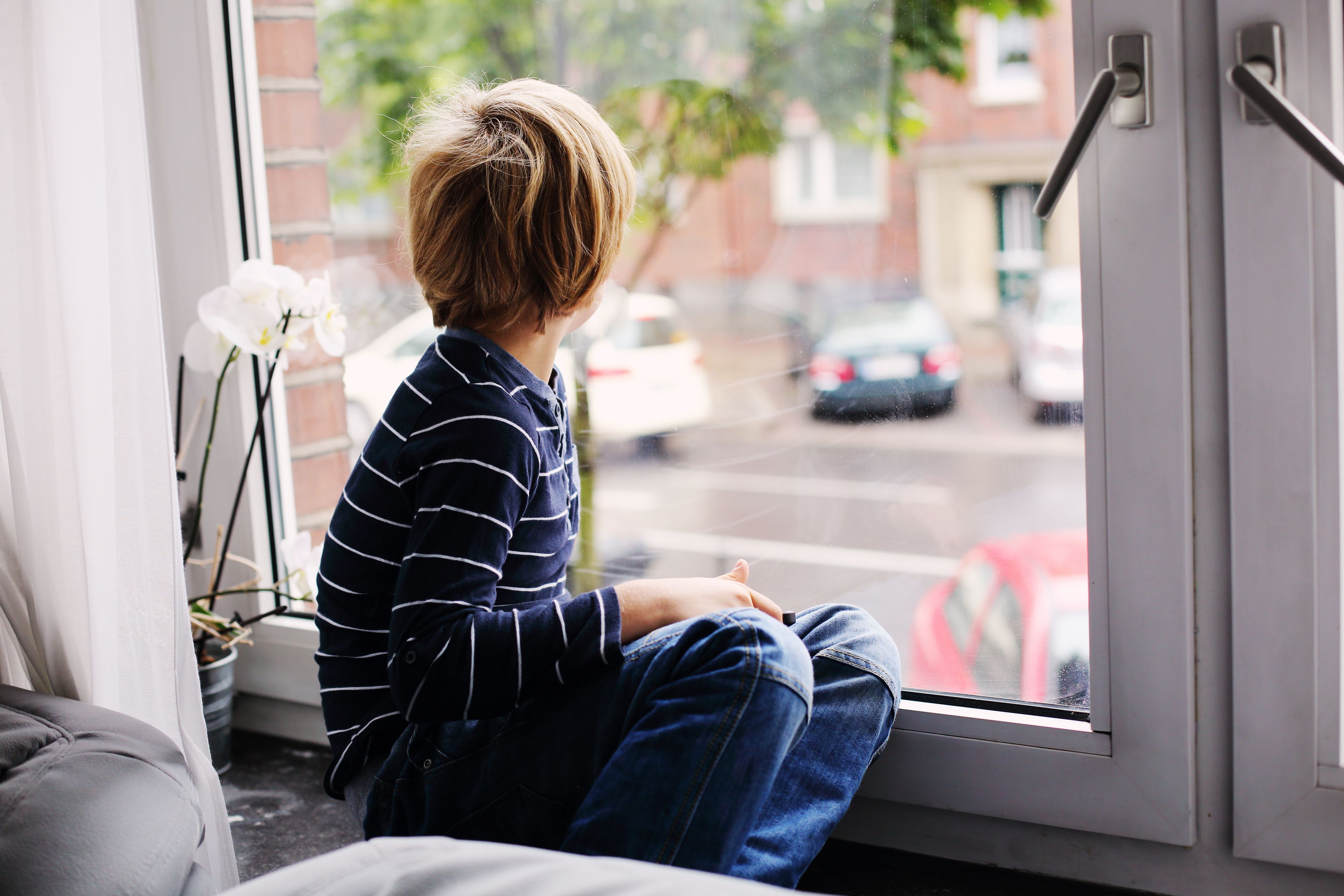 Грустный мальчик в окне. Мальчик у окна. Ребенок на подоконнике. Ребенок у окна. Мальчик смотрит в окно.