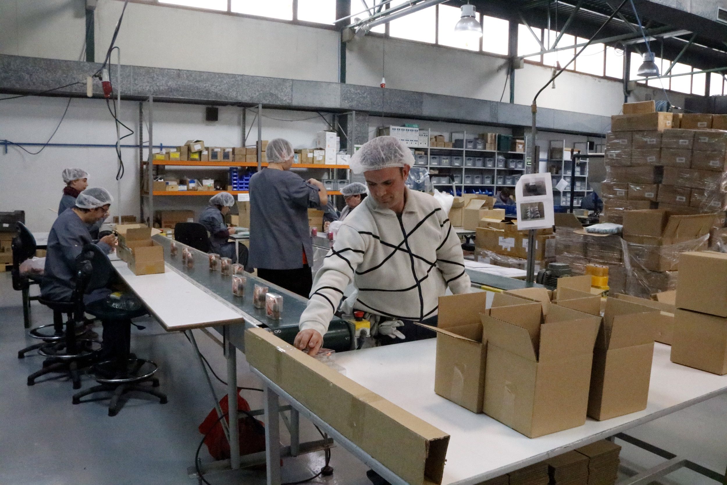 Trabajadores de Àuria Grupo en una de las líneas de producción en el sector de la cosmética | ACN Trabajadores de Àuria Grupo en una de las líneas de producción en el sector de la cosmética | ACN