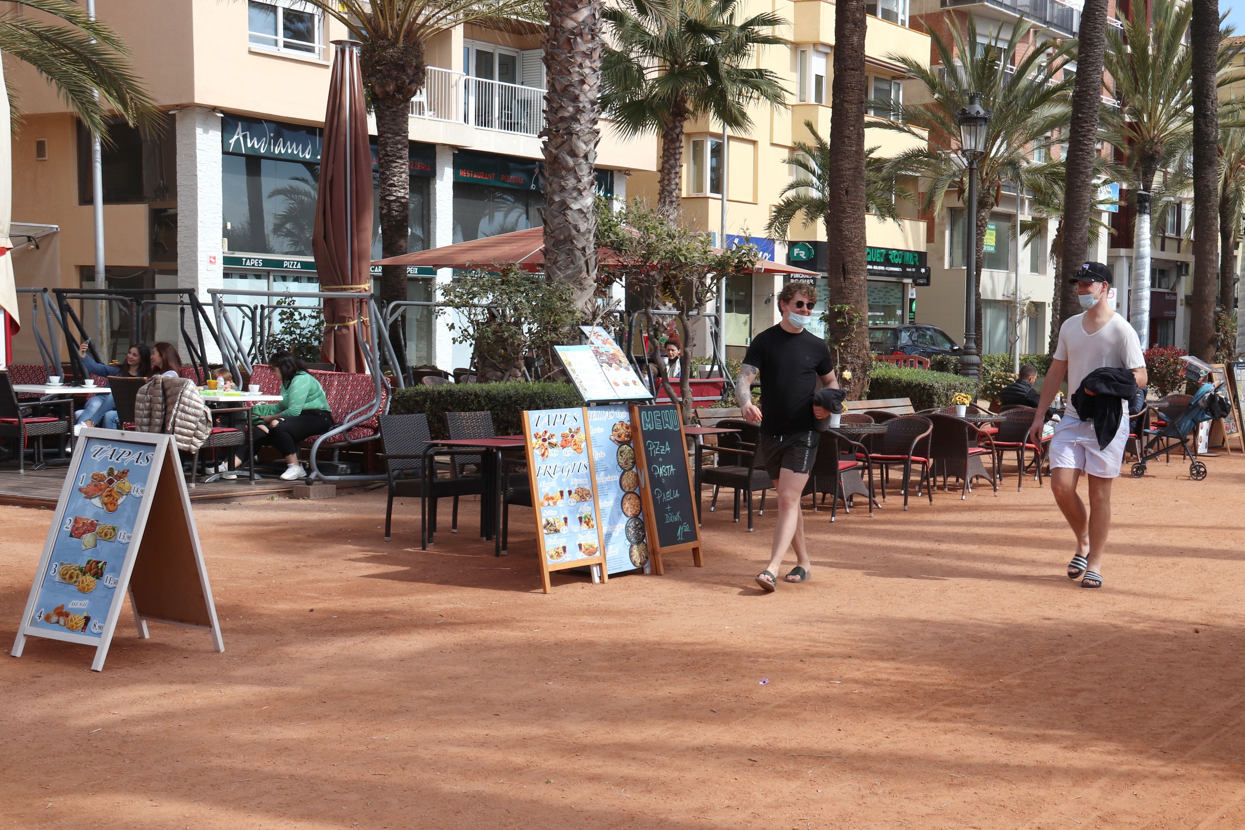 Diverses terrasses del passeig de Jacint Verdaguer de Lloret de Mar amb dos turistes passejant | ACN Diverses terrasses del passeig de Jacint Verdaguer de Lloret de Mar amb dos turistes passejant | ACN