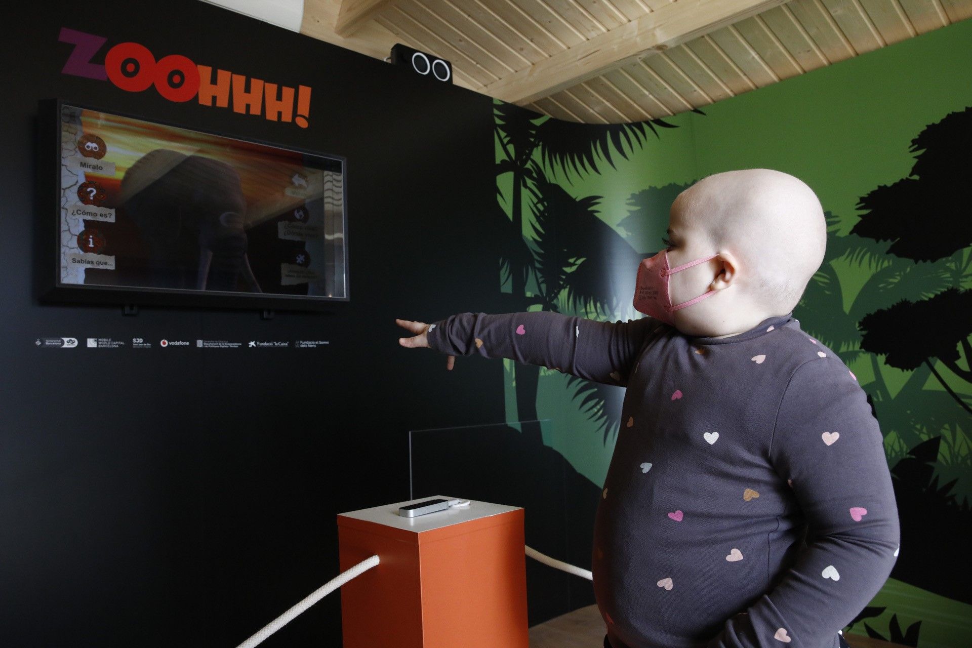 Olivia, una niña ingresada en Sant Joan de Déu, jugando con la cabina instalada en el exterior del centro | Cedida