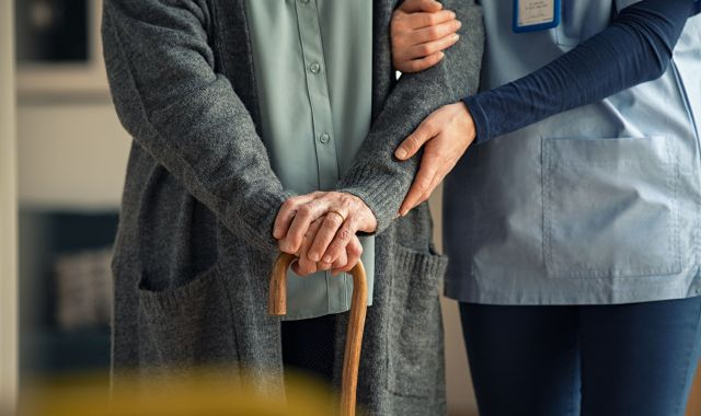 Una persona gran s'aguanta dreta amb l'ajuda d'un bastó | iStock