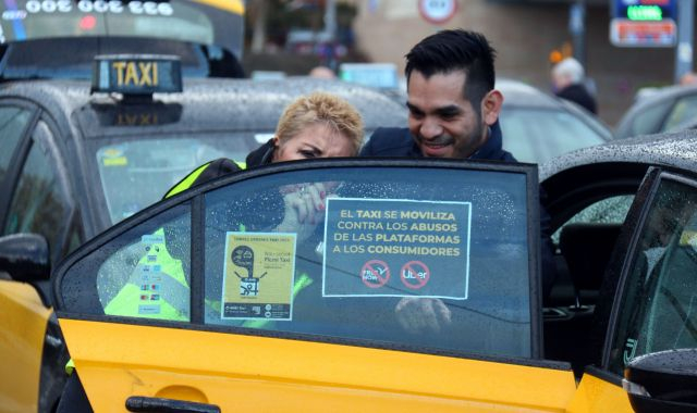 Dos taxistes enganxen un dels cartells reivindicatius amb motiu de la marxa lenta contra Free Now | ACN