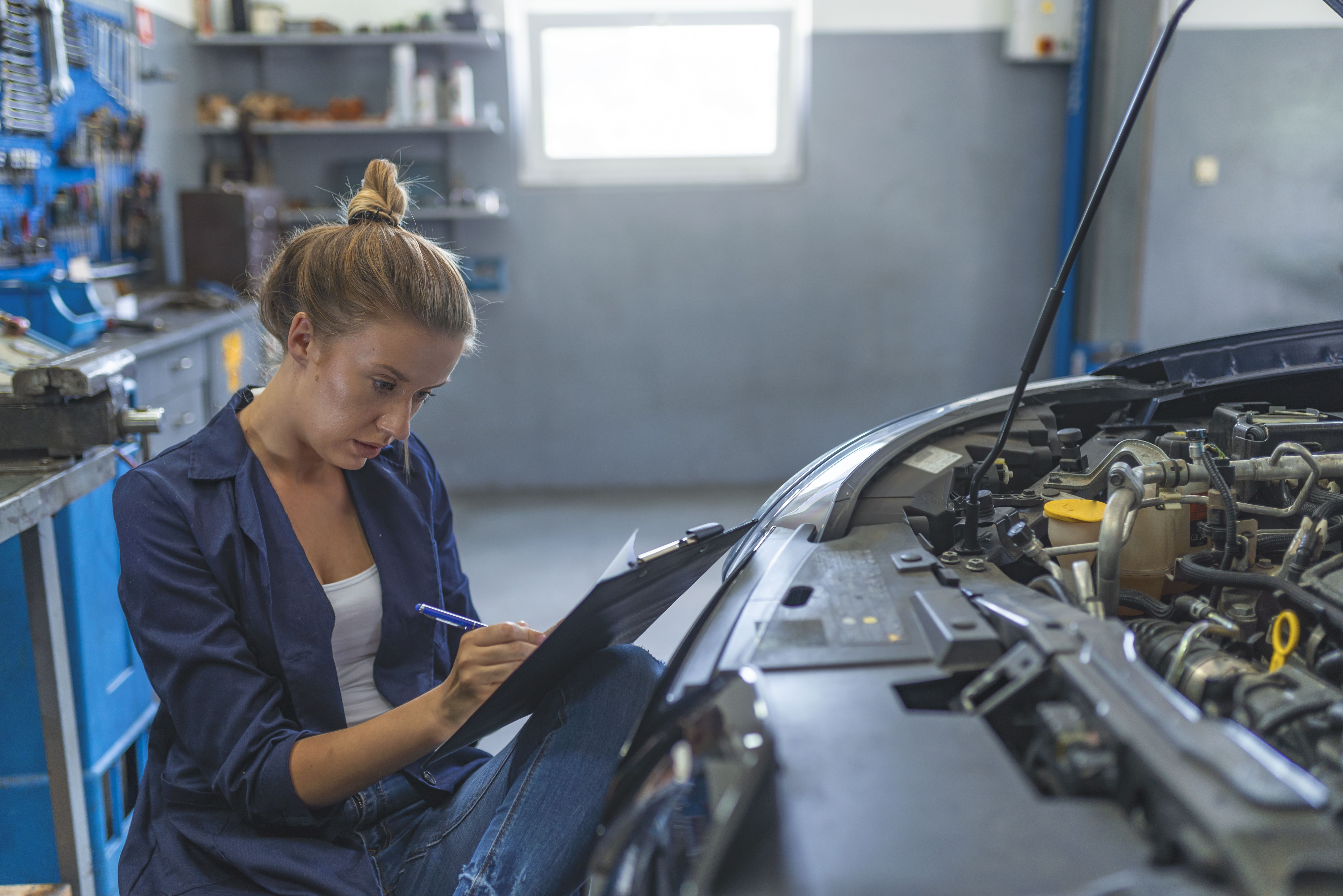 Dona en un centre de servei de reparació d'automòbils | iStock Dona en un centre de servei de reparació d'automòbils | iStock