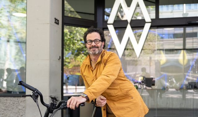 Enric Jové a la porta de McCann amb la seva Brompton, la bicicleta elèctrica amb la qual es mou per Barcelona | FOTO: Carolina Santos