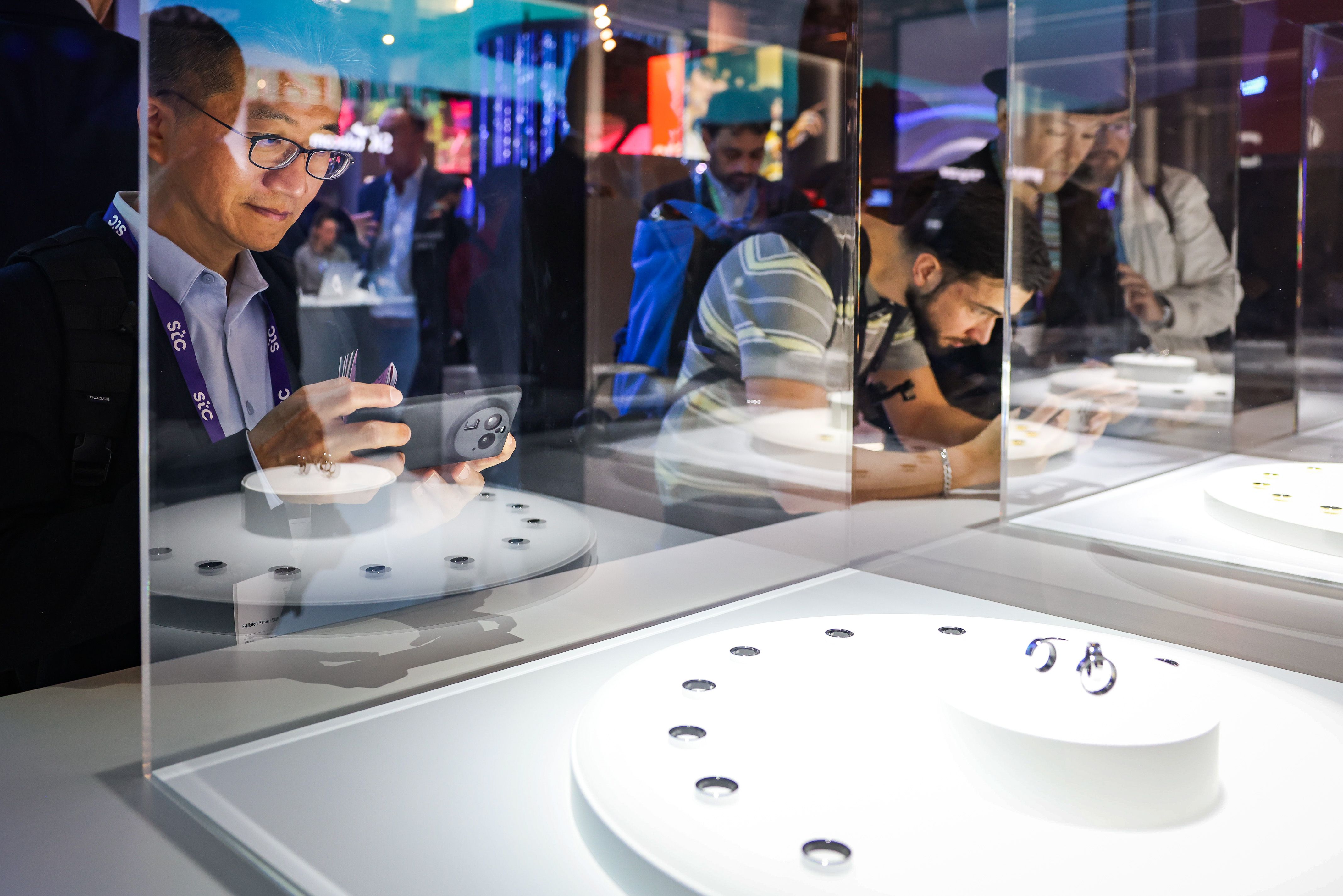 Diversos visitants fan fotografies amb el mòbil en un dels estands del MWC 2024 | ACN