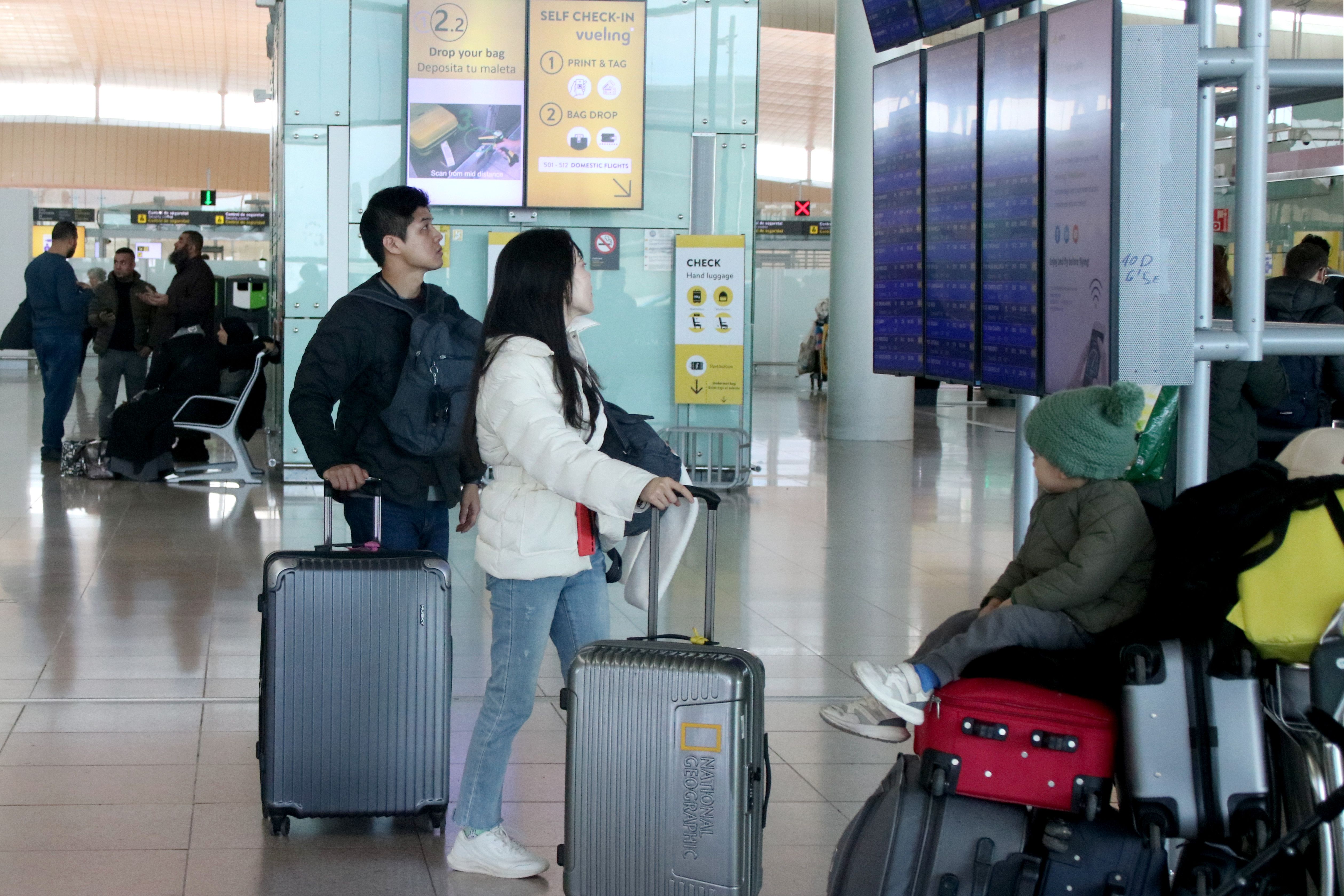 Usuarios consultando en los paneles informativos de los vuelos en la T1 del aeropuerto de El Prat | ACN