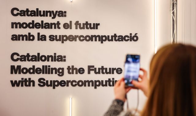 Una dona fa una fotografia al lema de Catalunya al MWC24 | ACN