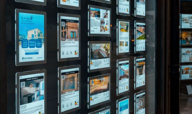 Diversos anuncis de pisos en venda en una agència immobiliària | iStock