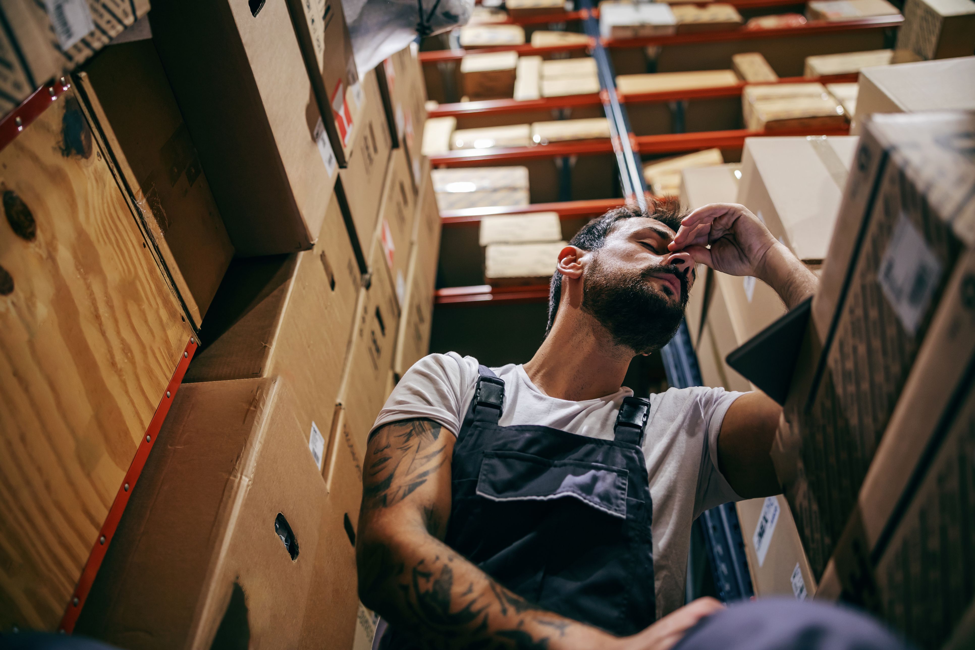 Trabajador estresado en su puesto de trabajo | iStock