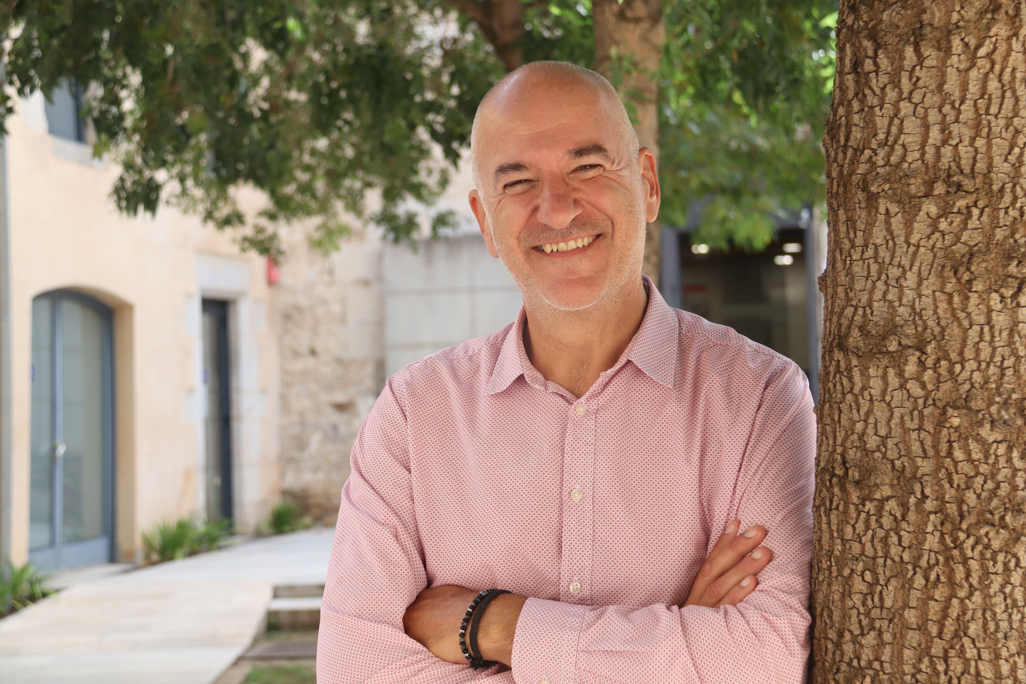 El párroco de la UdG, Quim Salvi, apoyado en un árbol en el patio interior de las Águilas de la universidad | ACN