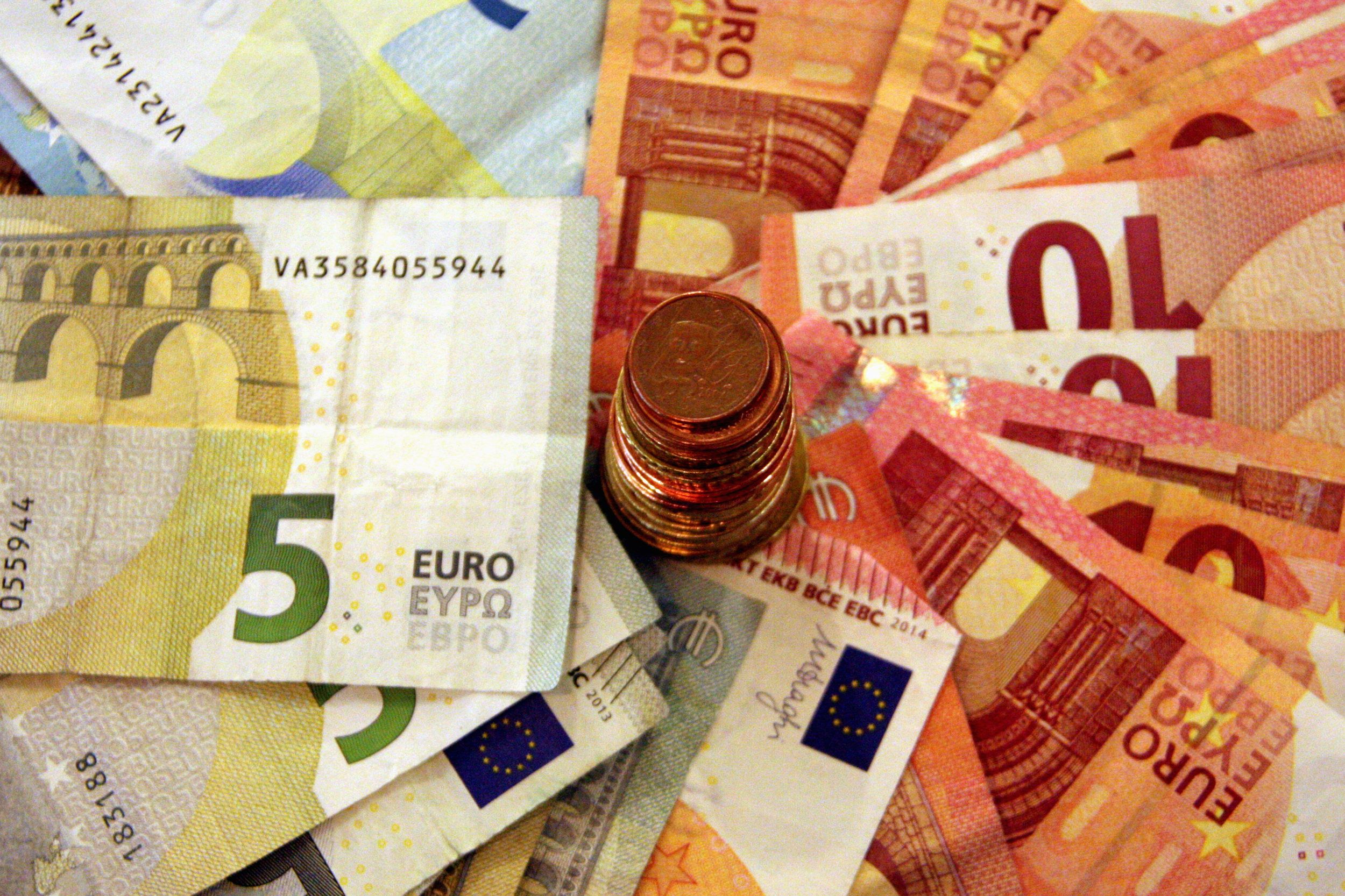 Una pila de bitllets amb una torre de monedes d'euro al centre | ACN Una pila de bitllets amb una torre de monedes d'euro al centre | ACN