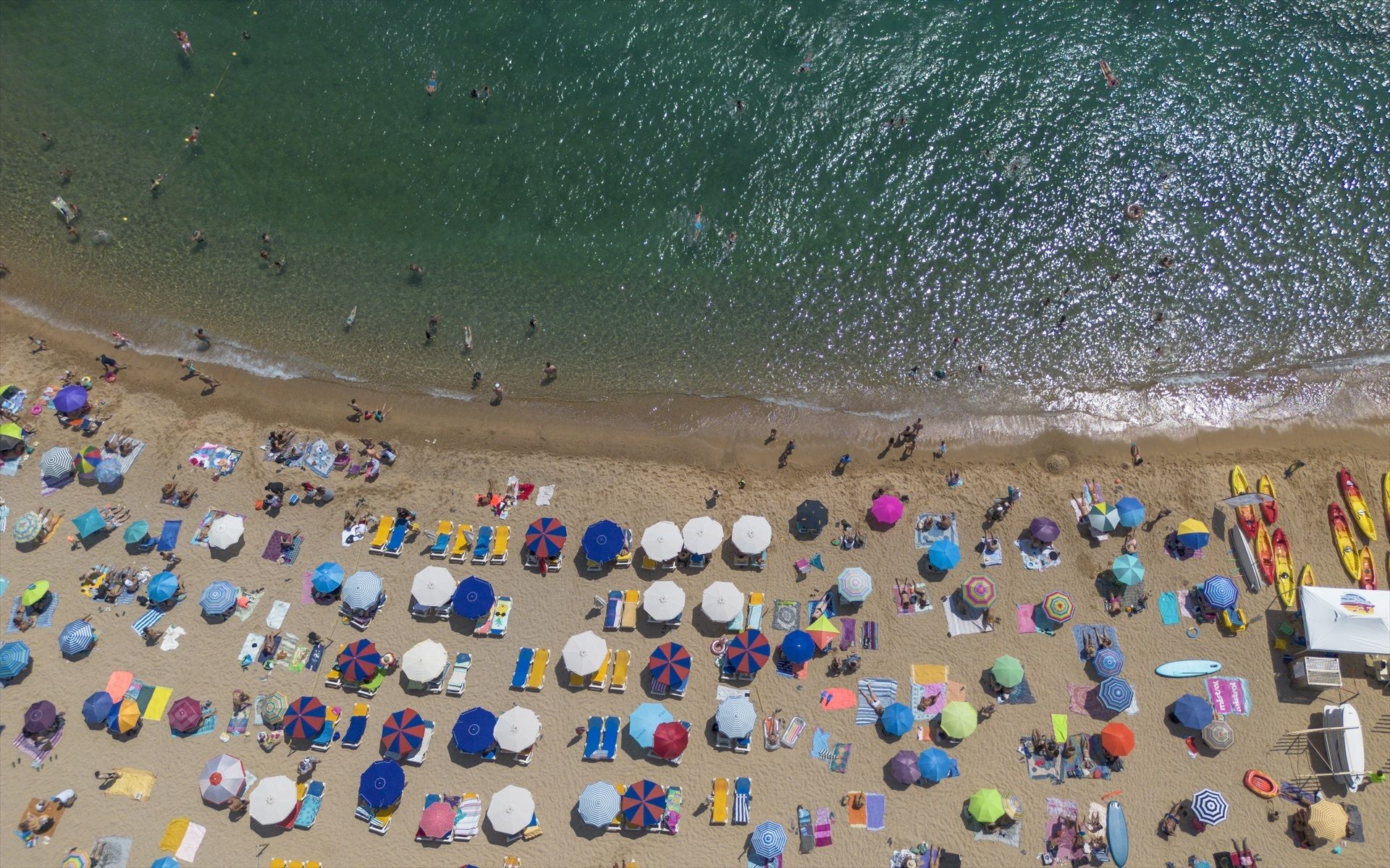 Numerosas personas disfrutan de una playa de Tossa de Mar, en la Costa Brava | Europa Press