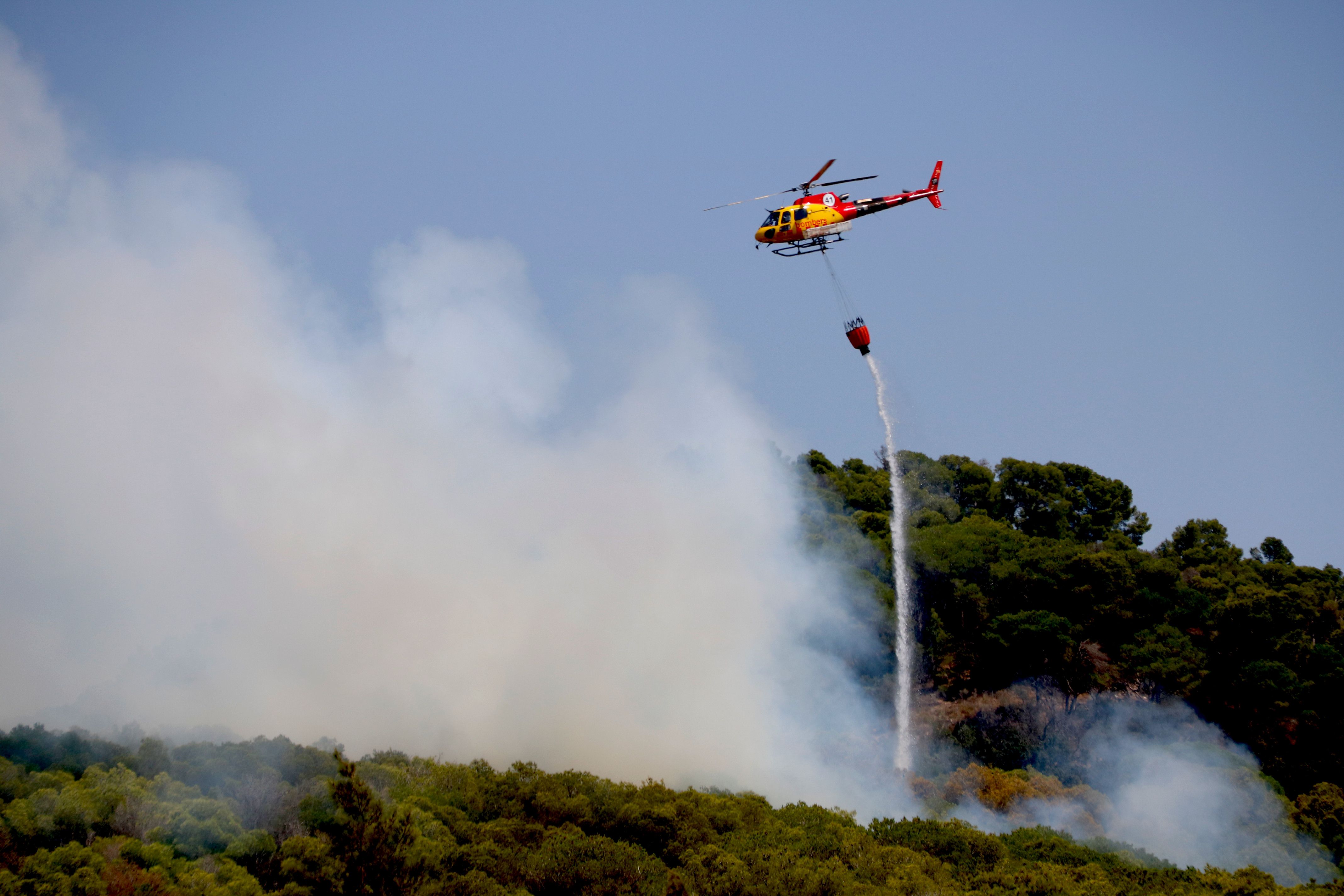 Un helicòpter descarrega aigua en un incendi forestal a Alforja | Arnau Martínez / ACN