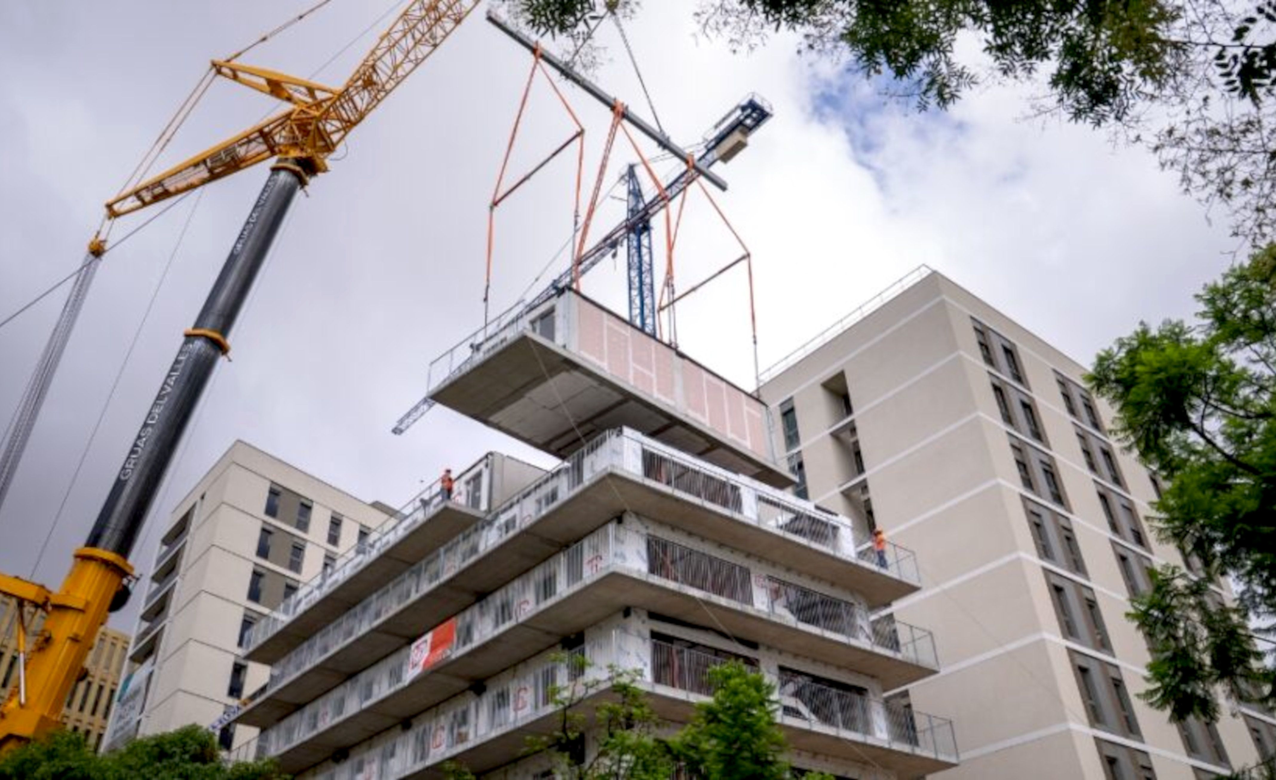 Una grua aixeca un dels blocs prefabricats per construir un edifici de pisos al barri de la Bordeta de Barcelona | Ajuntament de Barcelona Una grua aixeca un dels blocs prefabricats per construir un edifici de pisos al barri de la Bordeta de Barcelona | Ajuntament de Barcelona