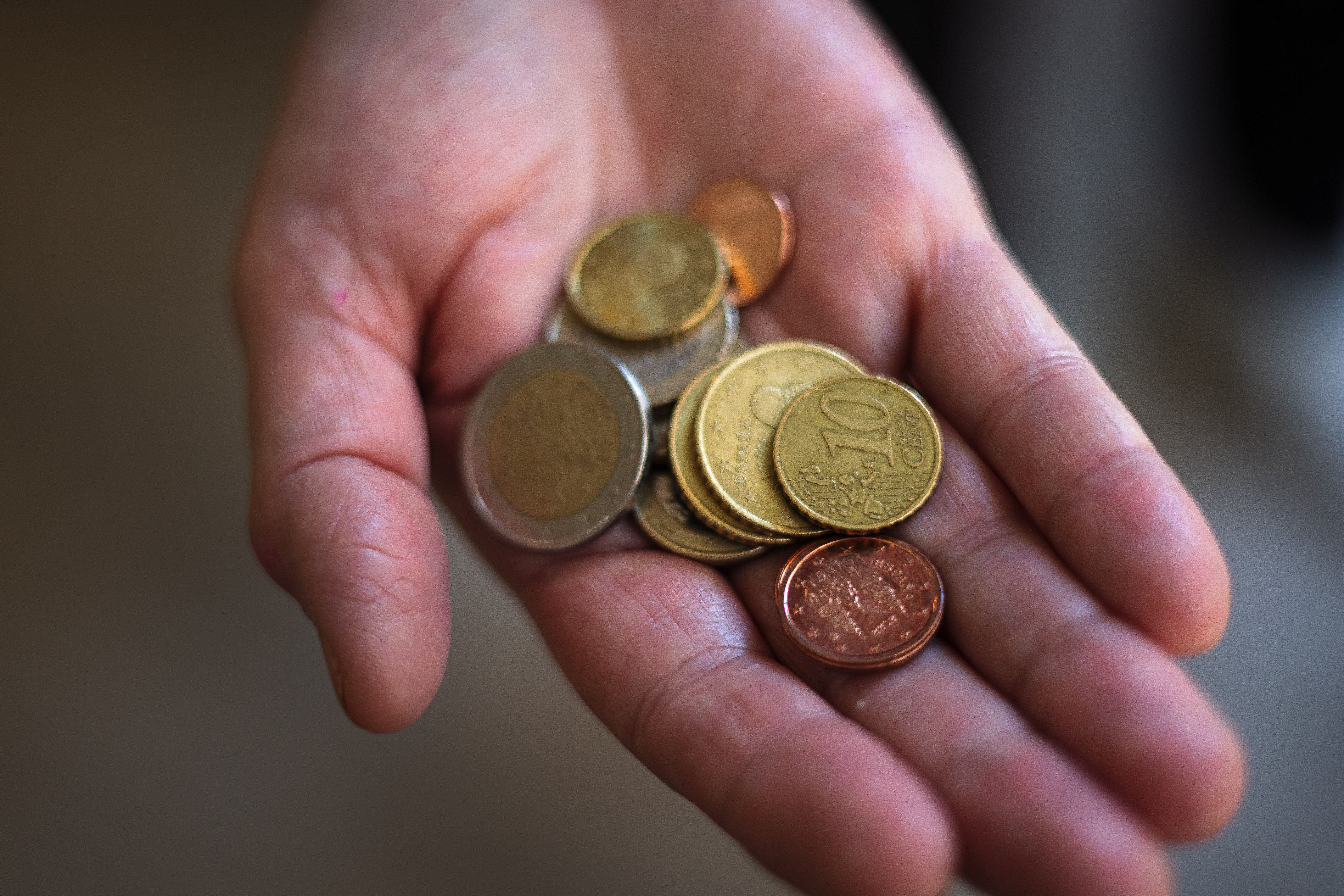 Una mano sostiene varias  monedas y céntimos de euro | Jordi Borràs / ACN