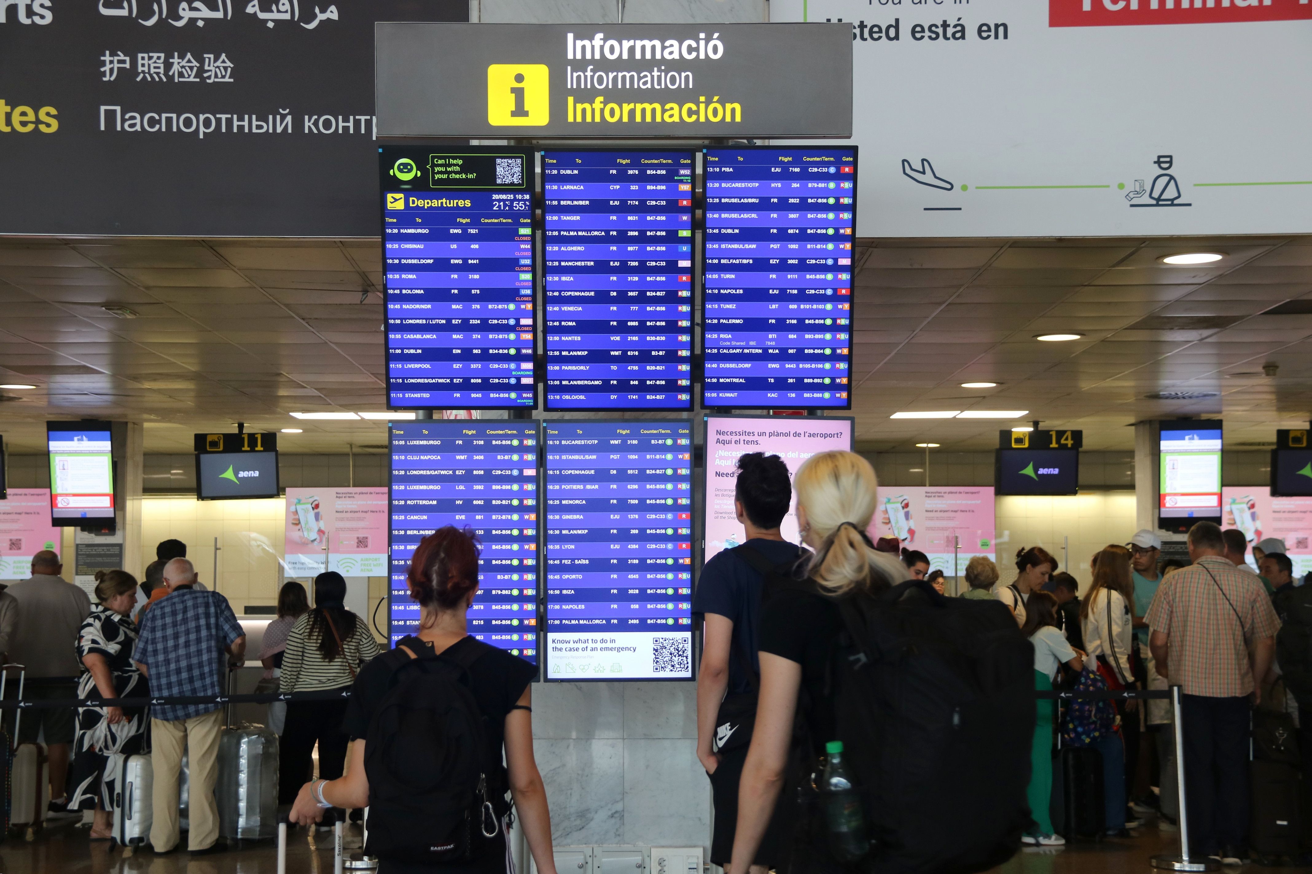Passatgers consultant les pantalles amb informació dels vols a la terminal 2 de l'aeroport del Prat | Maria Asmarat (ACN)