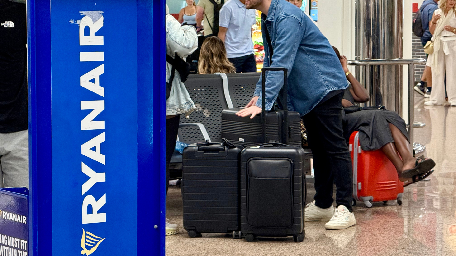 Un hombre carga maletas frente al acceso a los mostradores de Ryanair en la T2 del aeropuerto del Prat | Albert Segura (ACN)
