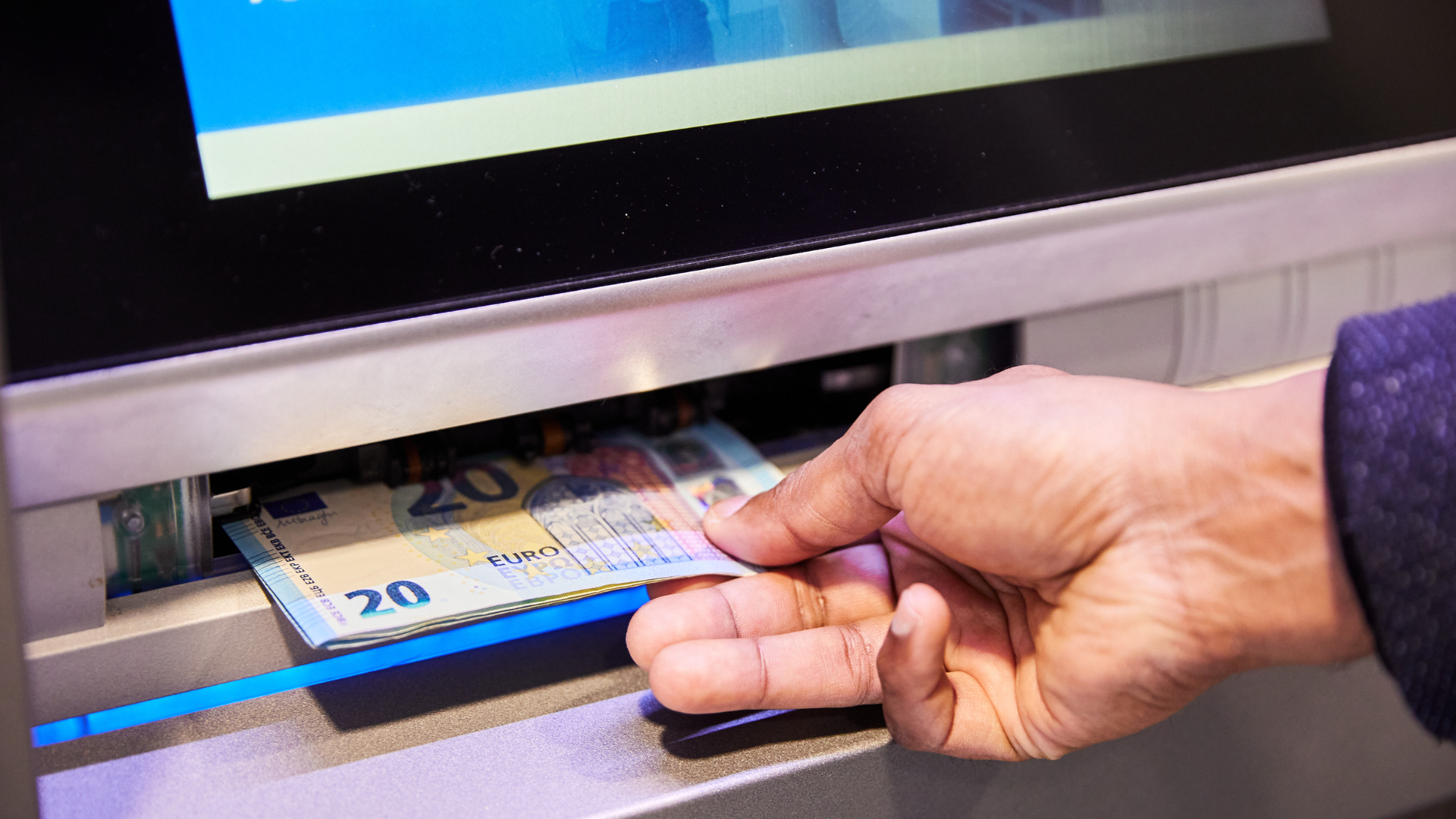 Una persona treu diners d'un caixer automàtic | Roger Gutiérrez (ACN)