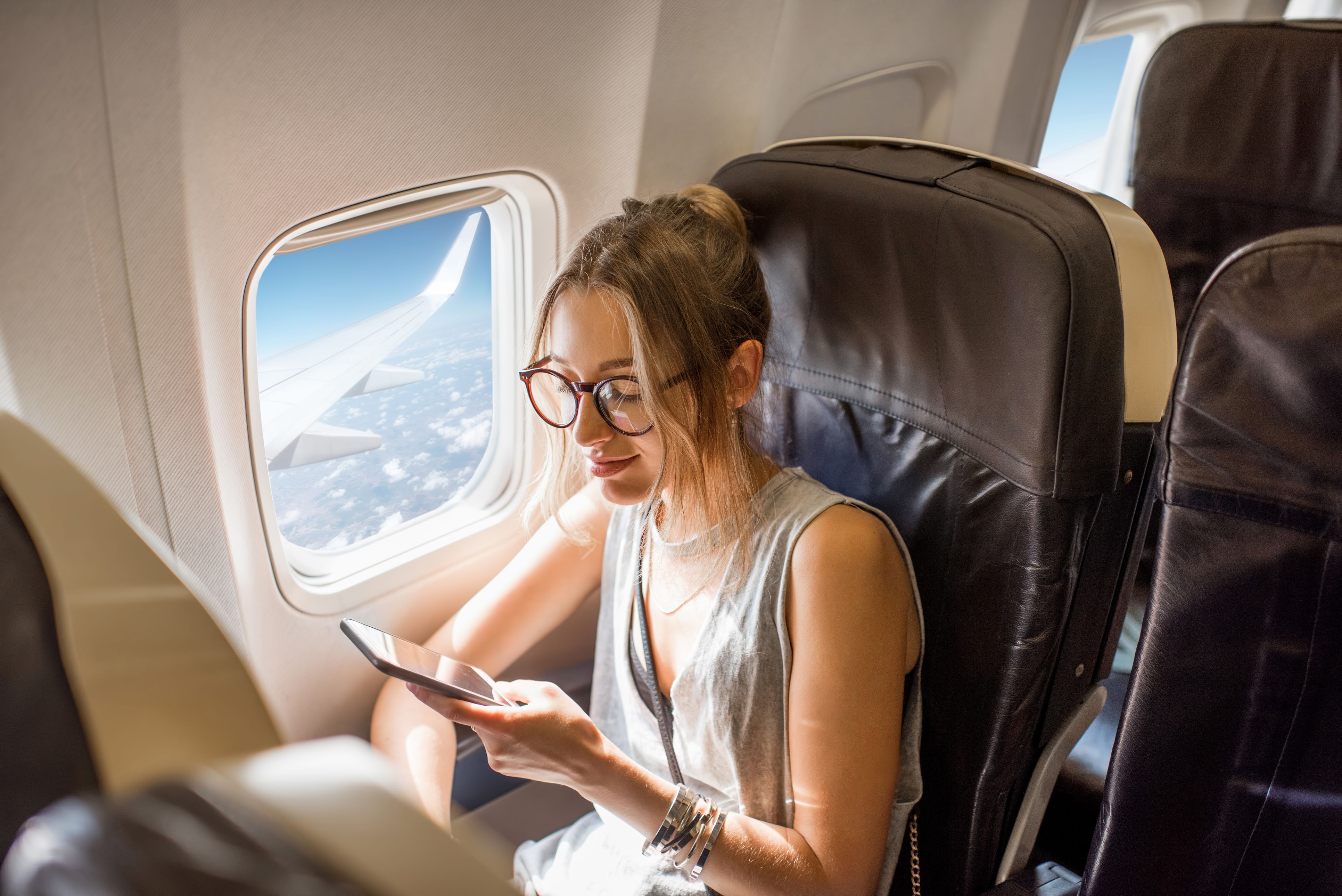 Una dona viatja sense wifi gratuït en un avió | iStock