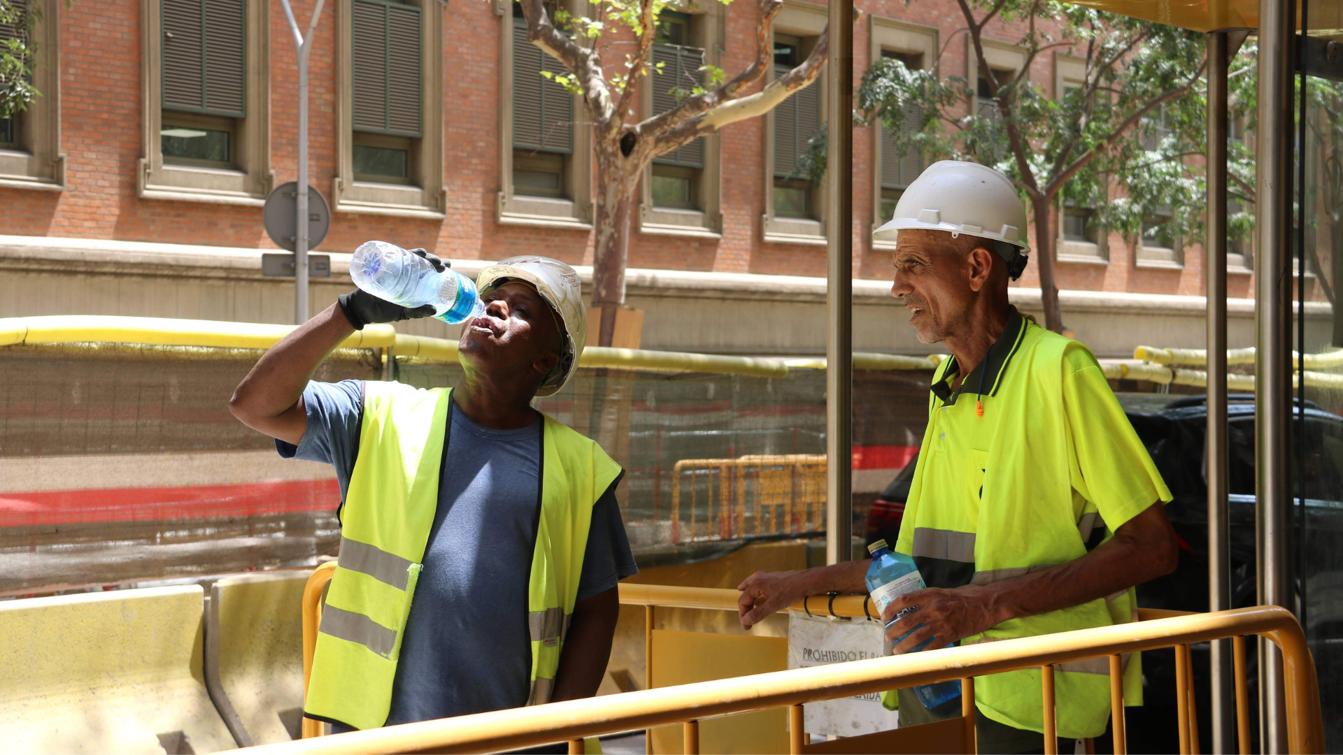 Uns obrers hidratant-se, després de treballar sota el sol | Laia Mariné (ACN)