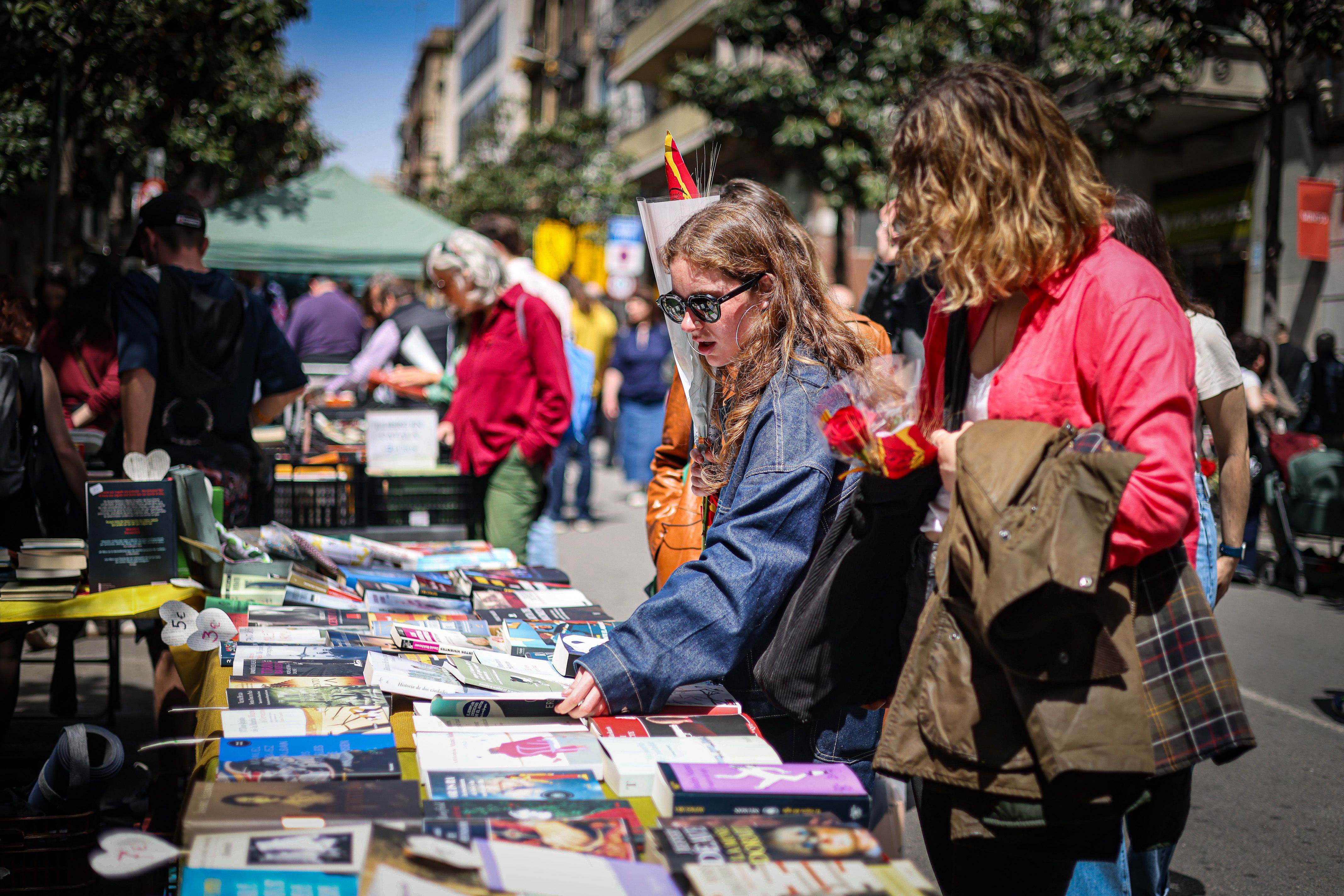 Gent passejant entre parades de llibres i roses a Gran de Gràcia per Sant Jordi a Barcelona | Jordi Borràs (ACN)