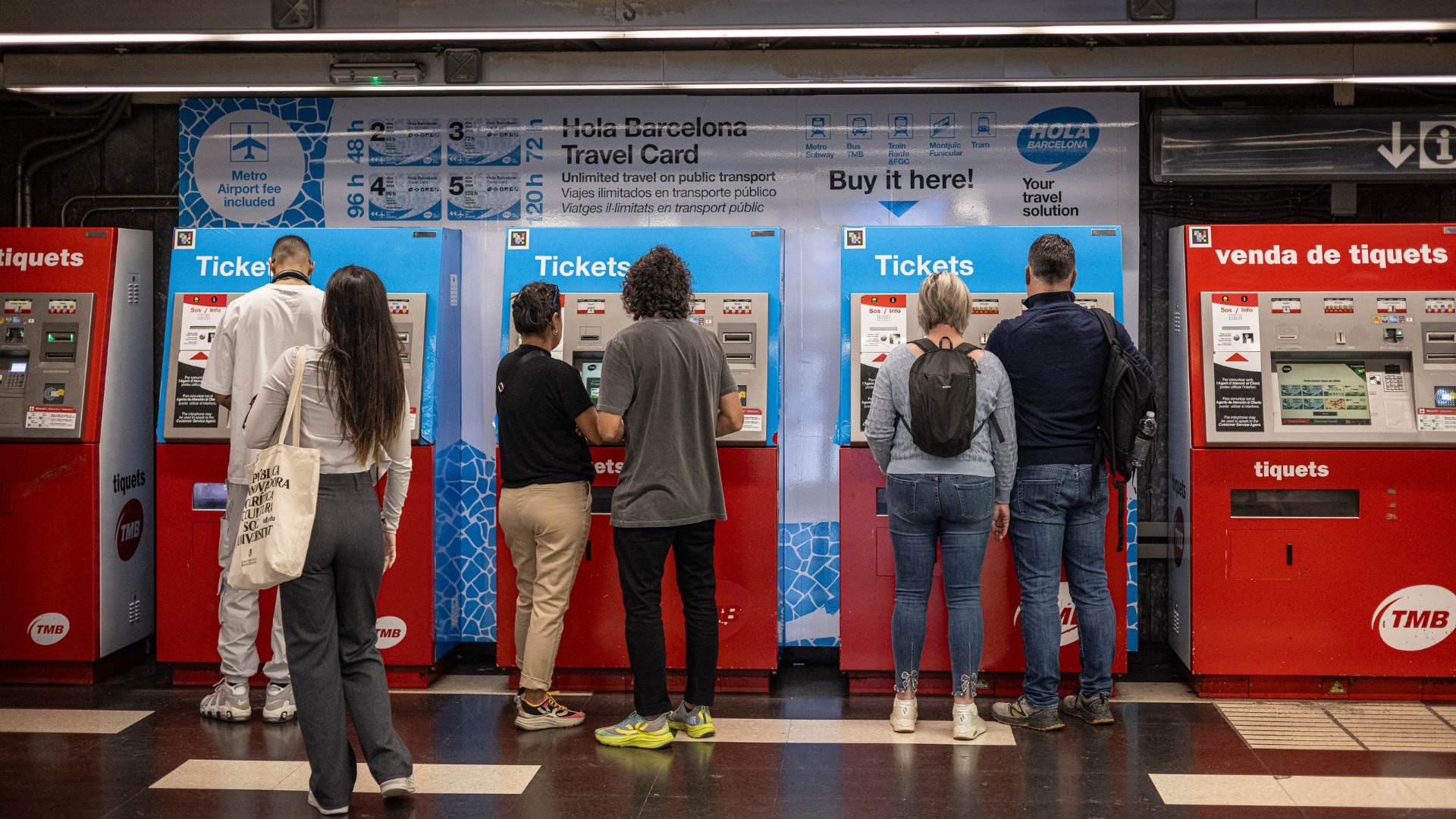 Diversas personas compran billetes o abonos de transporte público en las máquinas del metro de Barcelona | Jordi Borràs (ACN)