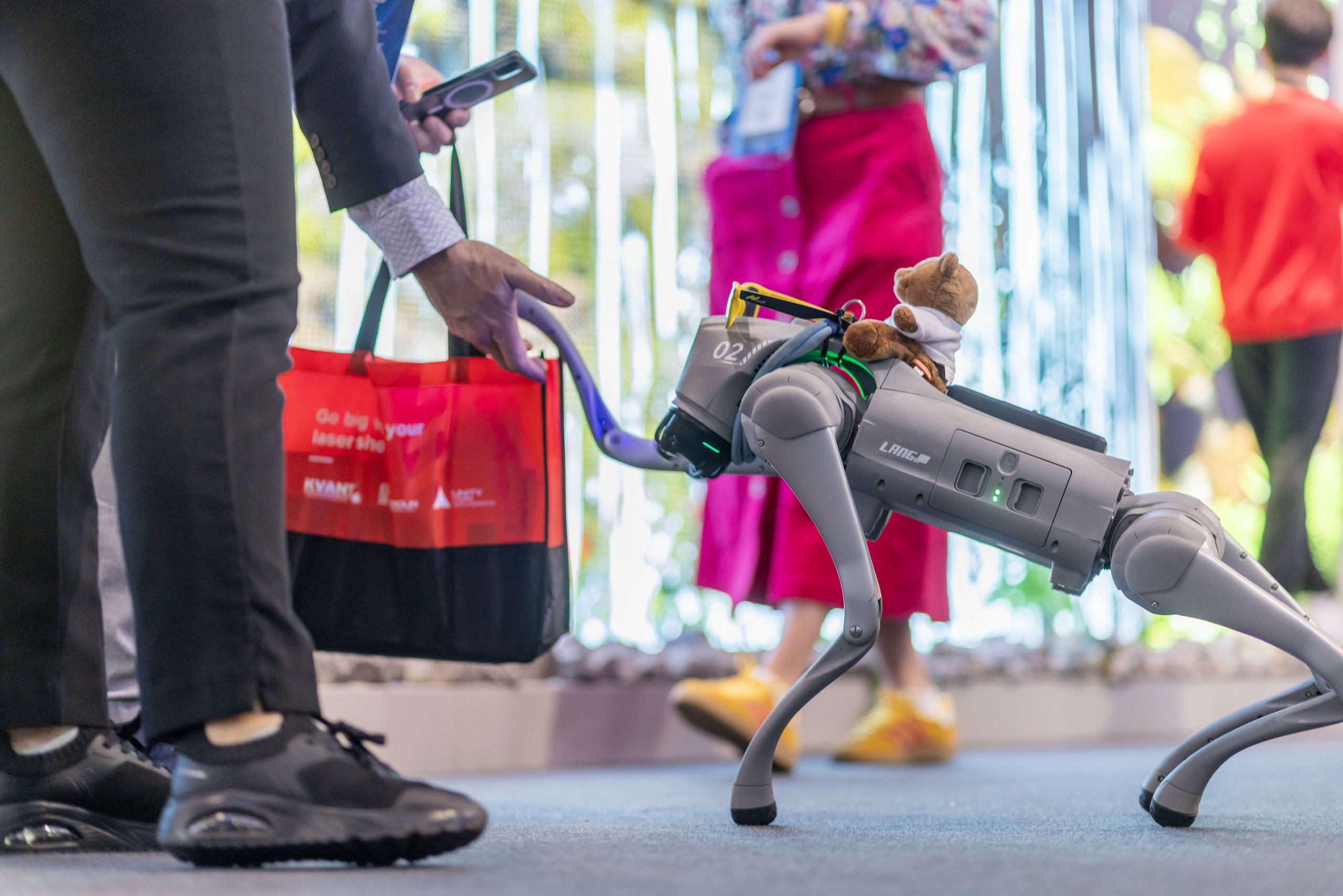 Un robot con forma de perro, saludando a un asistente del ISE | ISE