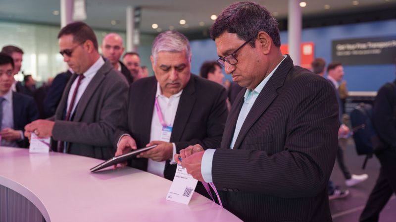 Congressistes al MWC revisen la seva documentació | Marc Font (ACN)