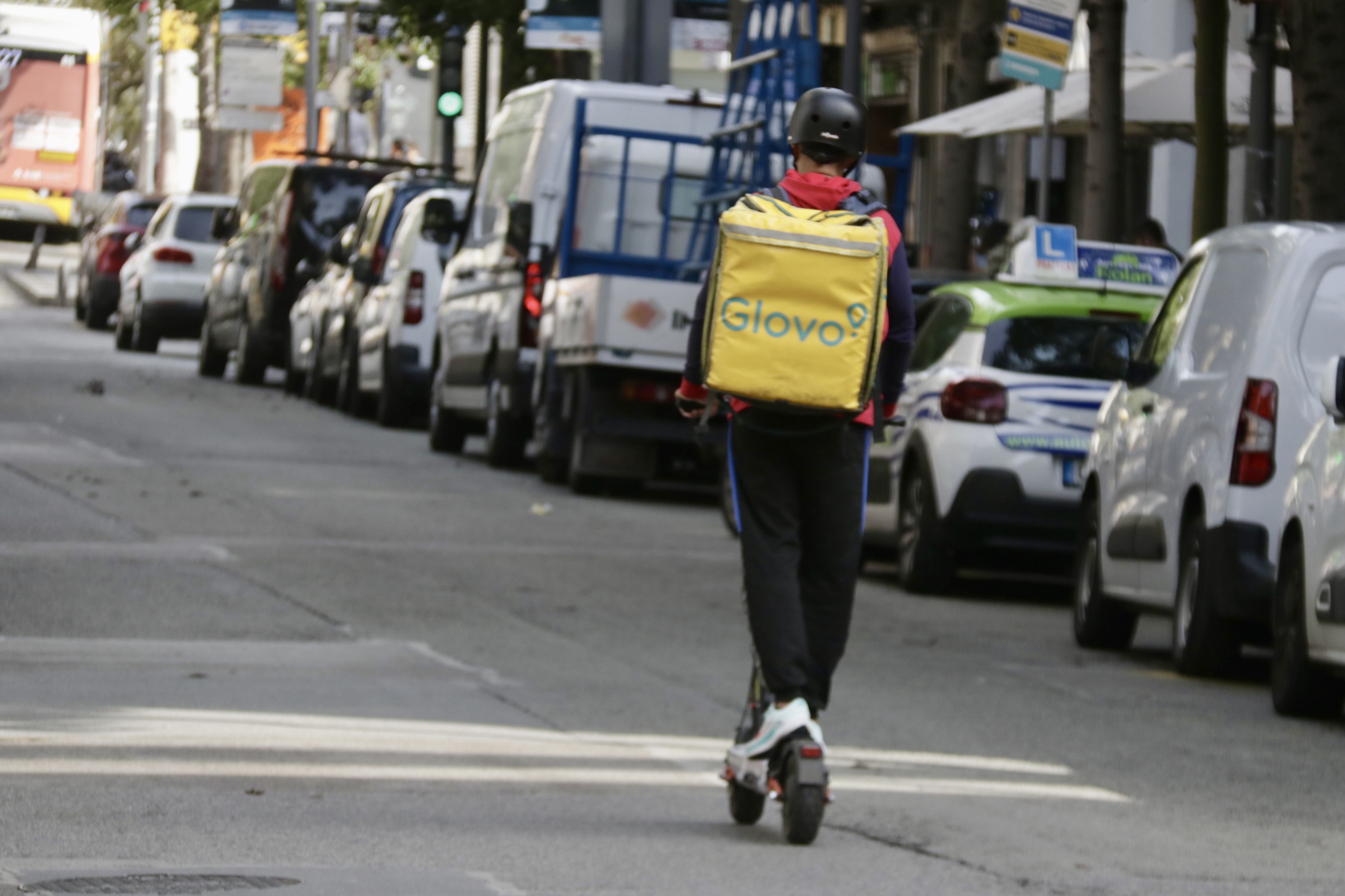 Un repartidor es desplaça en patinet elèctric pel centre de Badalona | Jordi Pujolar (ACN)