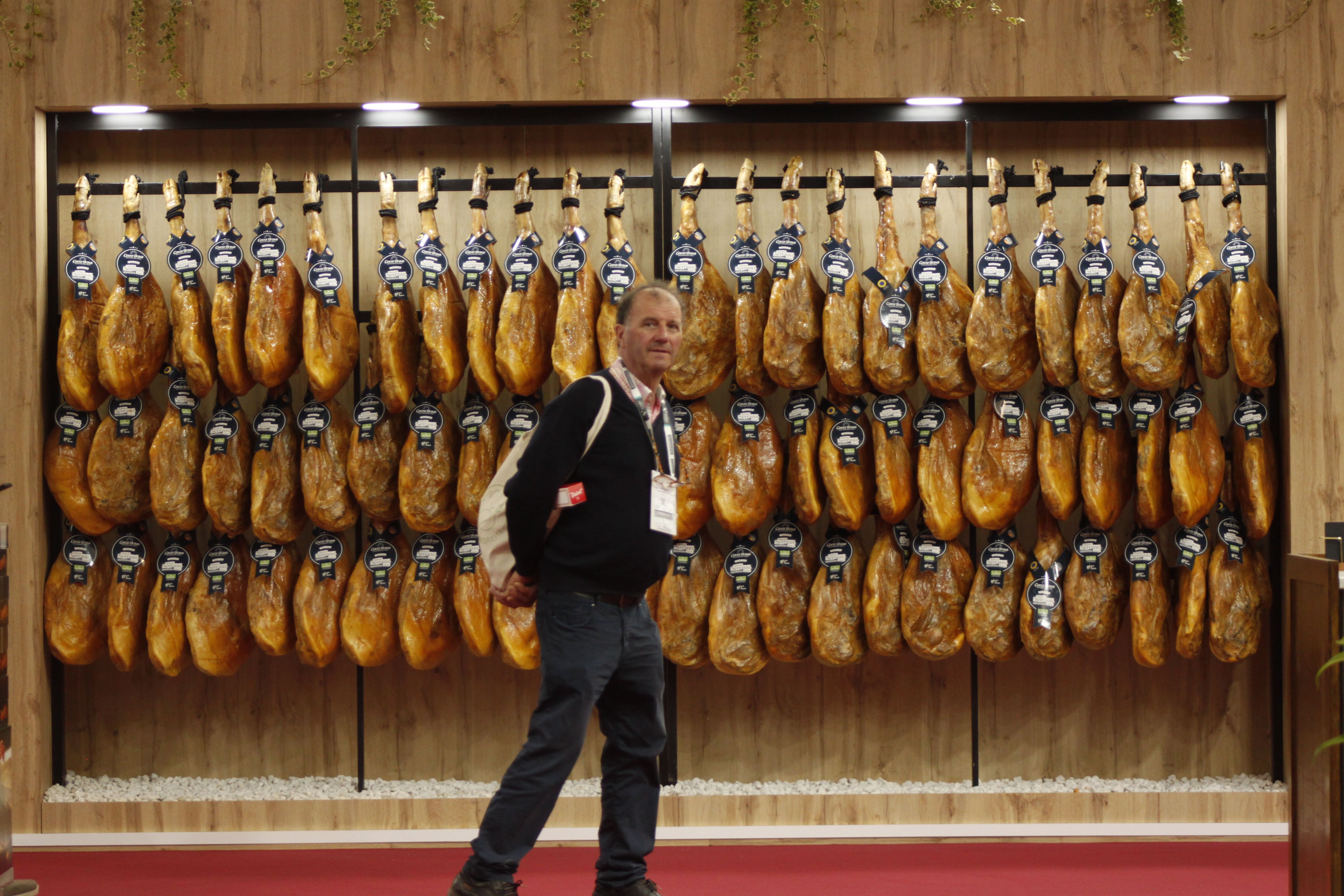 Un visitante en un stand de jamones en Alimentaria + Hostelco | David Lombrana