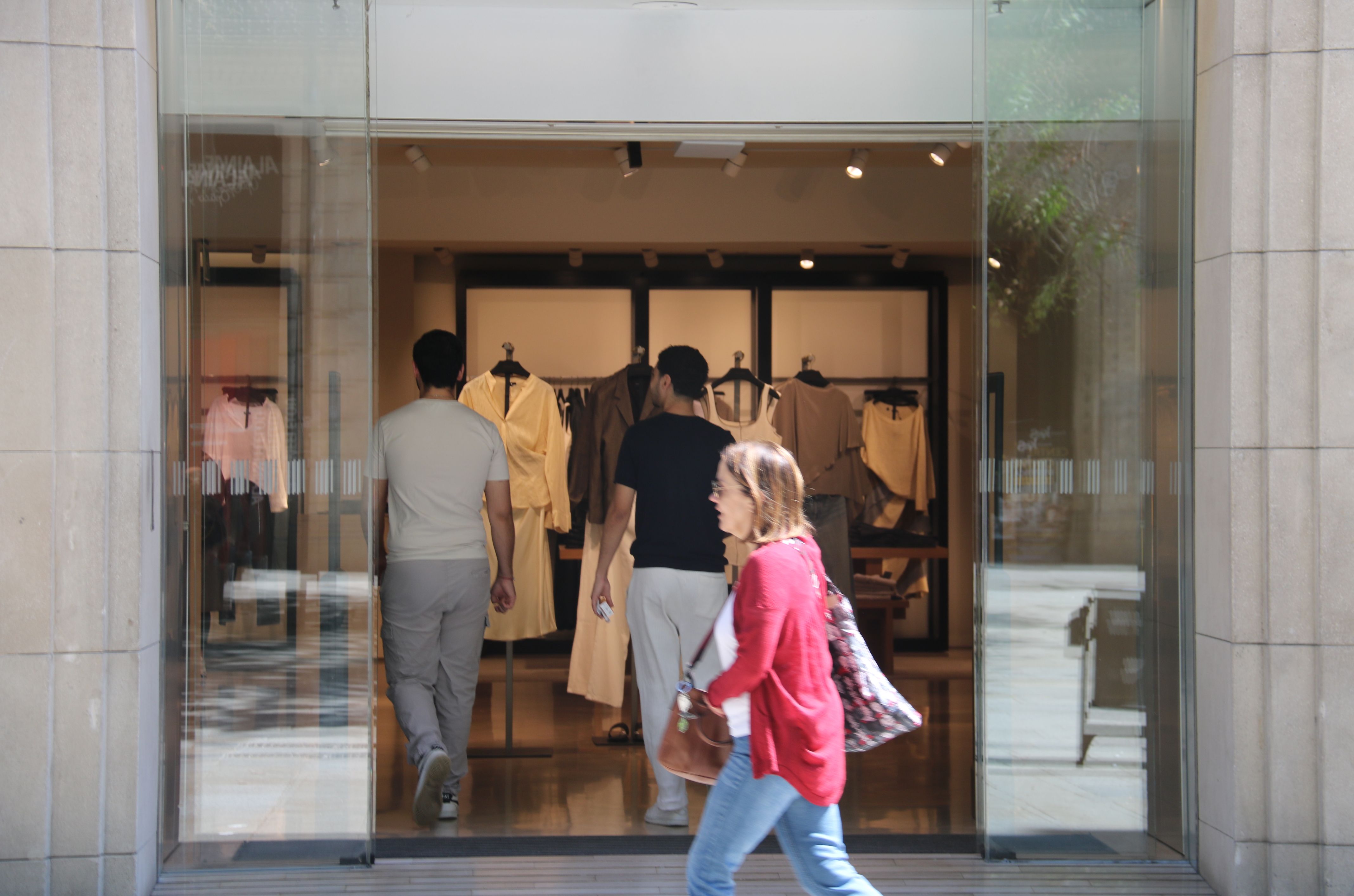 Dos jóvenes entran en una tienda de ropa del Portal de l'Àngel de Barcelona | Gerard Artigas (ACN)