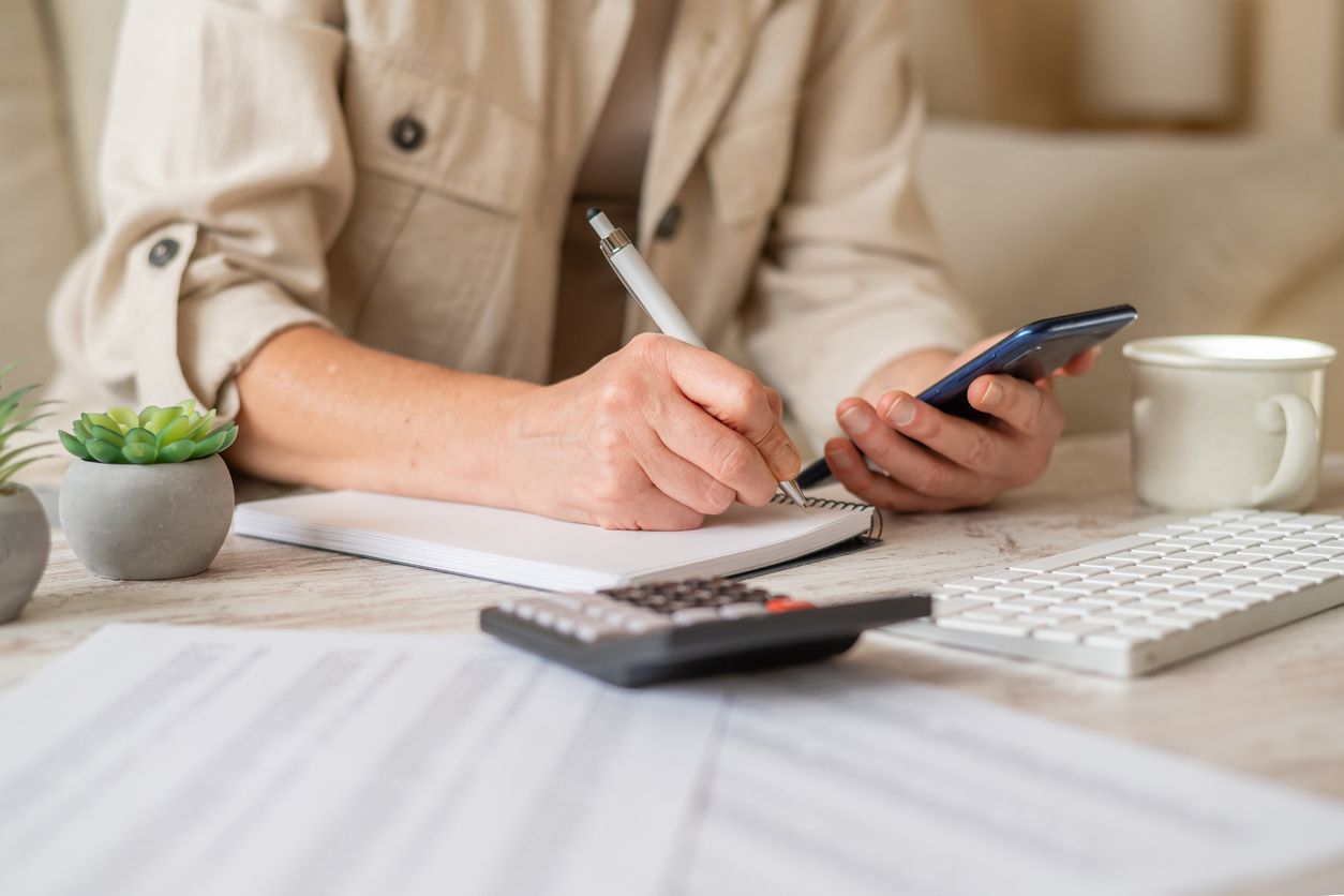 Una dona fa càlculs amb el seu telèfon mòbil | iStock