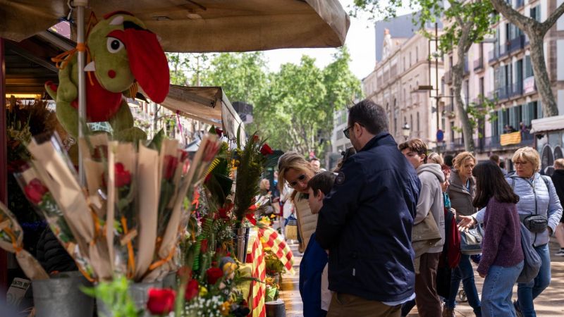 Una familia se detiene delante de un puesto de rosas en la Rambla de Barcelona para comprar | Paula Jaume (Imatges Barcelona)