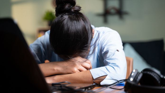 Una mujer padece de estrés en su escritorio de trabajo | iStock 