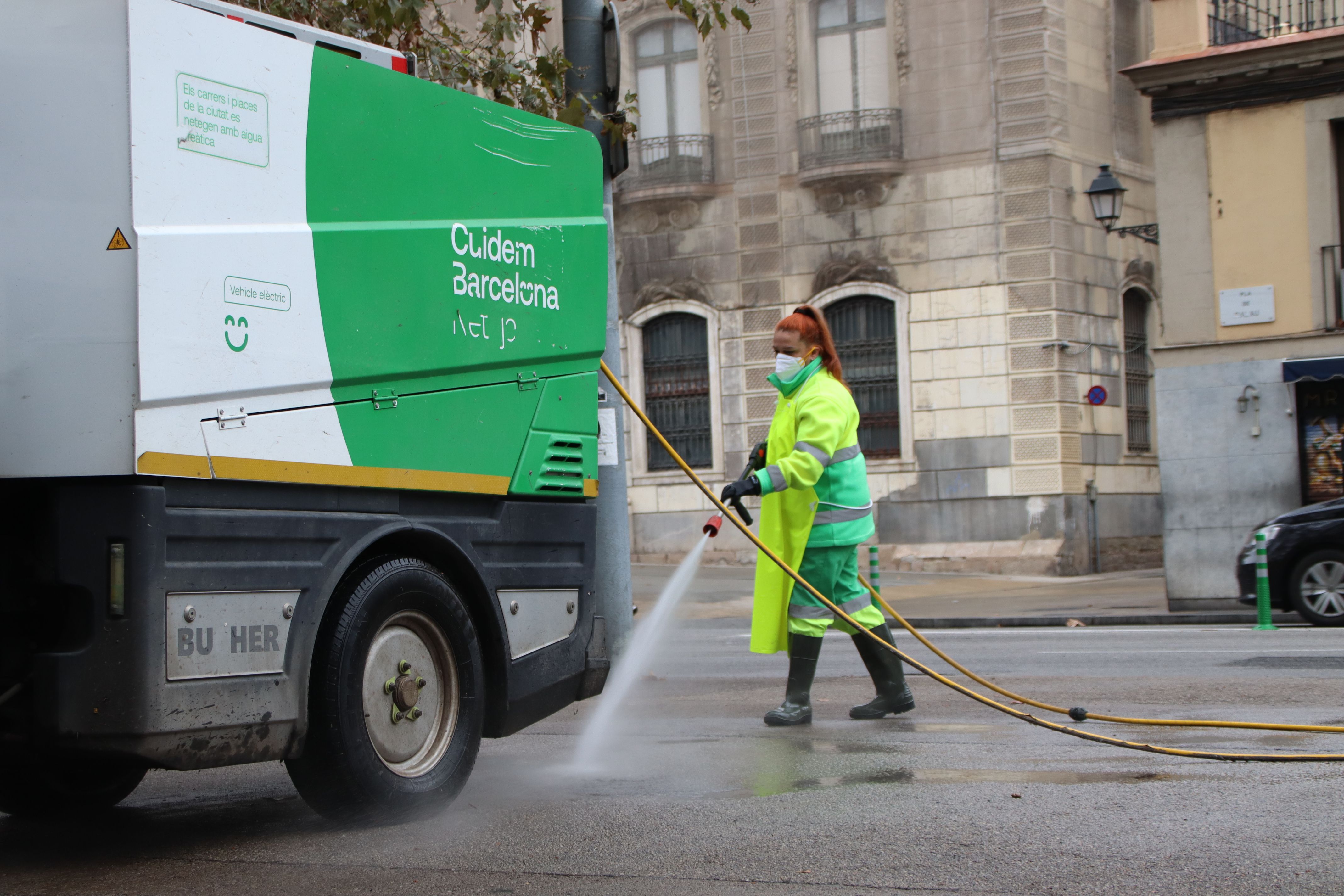 Una treballadora neteja el carrer amb aigua freàtica | Blanca Blay (ACN) Una treballadora neteja el carrer amb aigua freàtica | Blanca Blay (ACN)