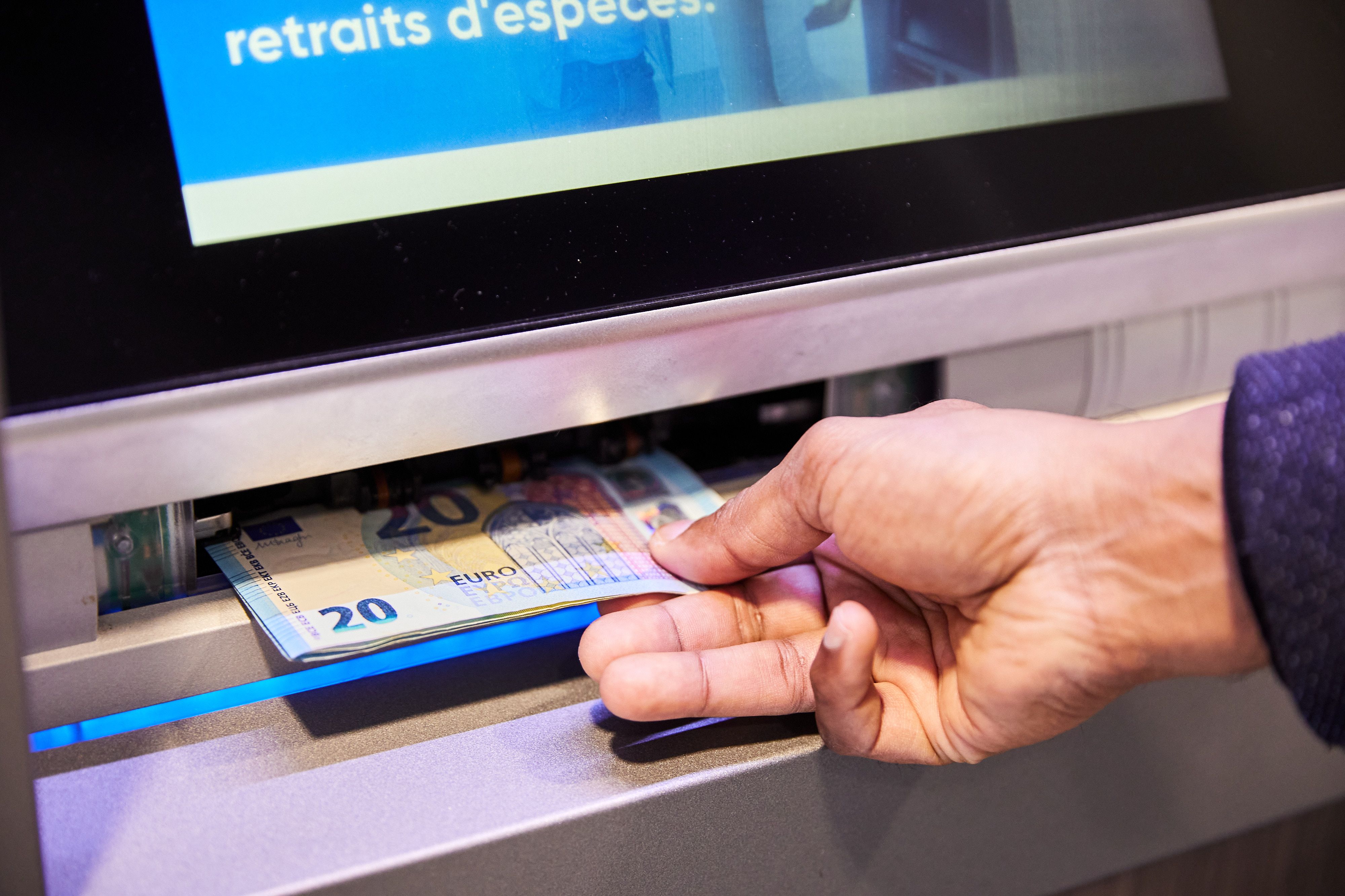Una persona treu diners d'un caixer automàtic | Roger Gutiérrez (ACN)
