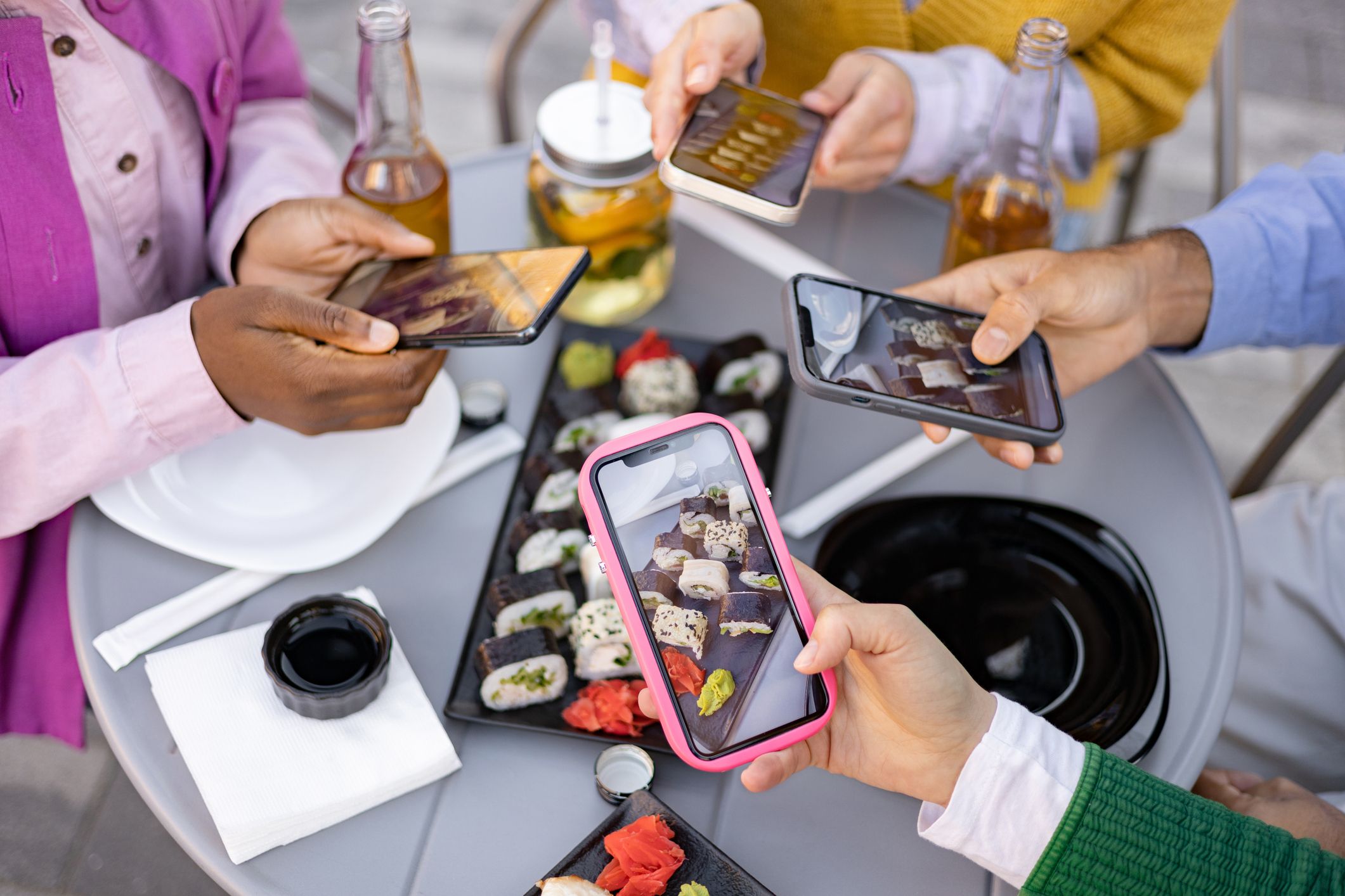 Amics fotografiant sushi junts | iStock