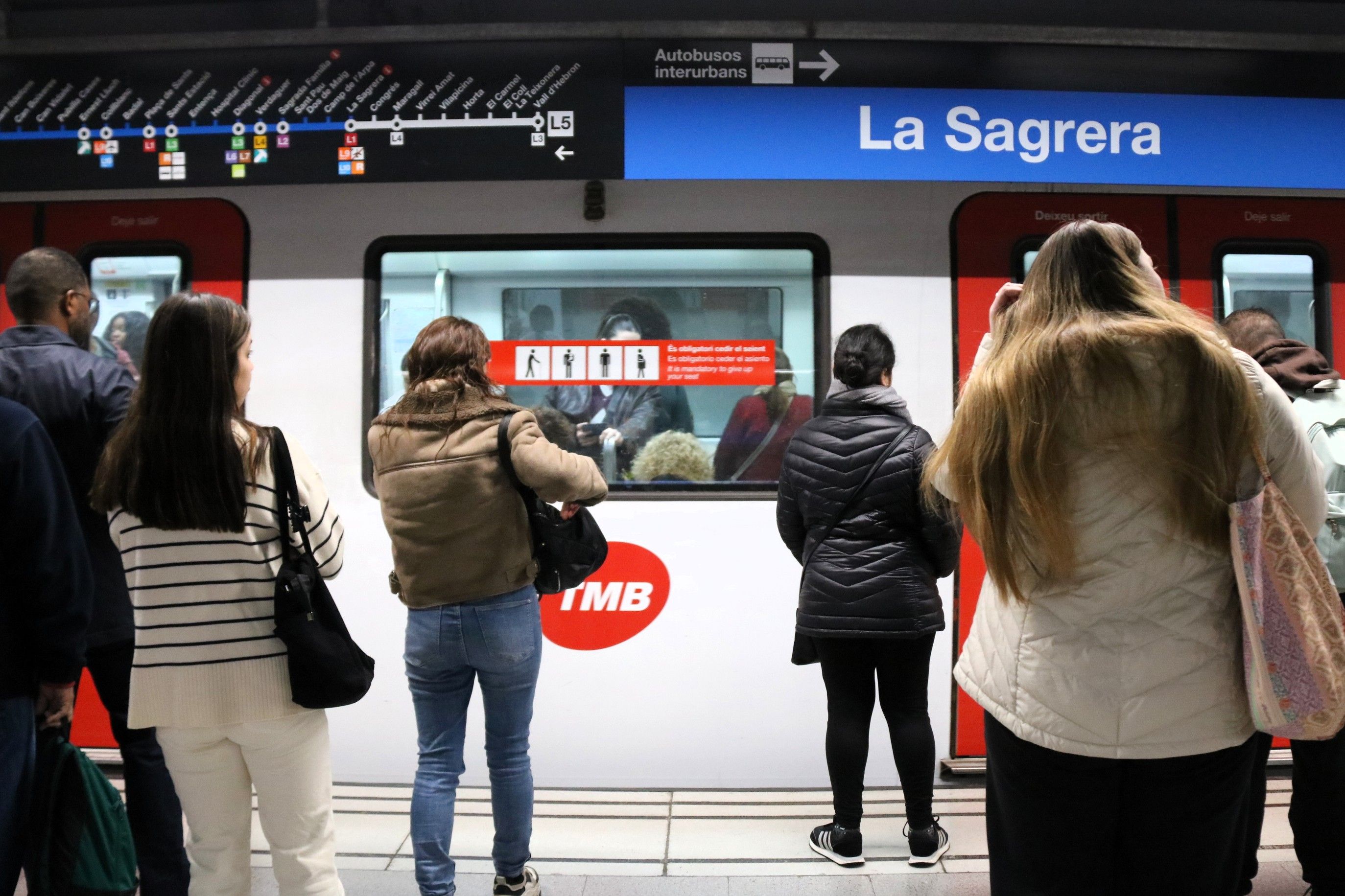 Uns usuaris esperant a l'andana de la Sagrera de la línia 5 del metro de Barcelona | Andrea Salazar (ACN)