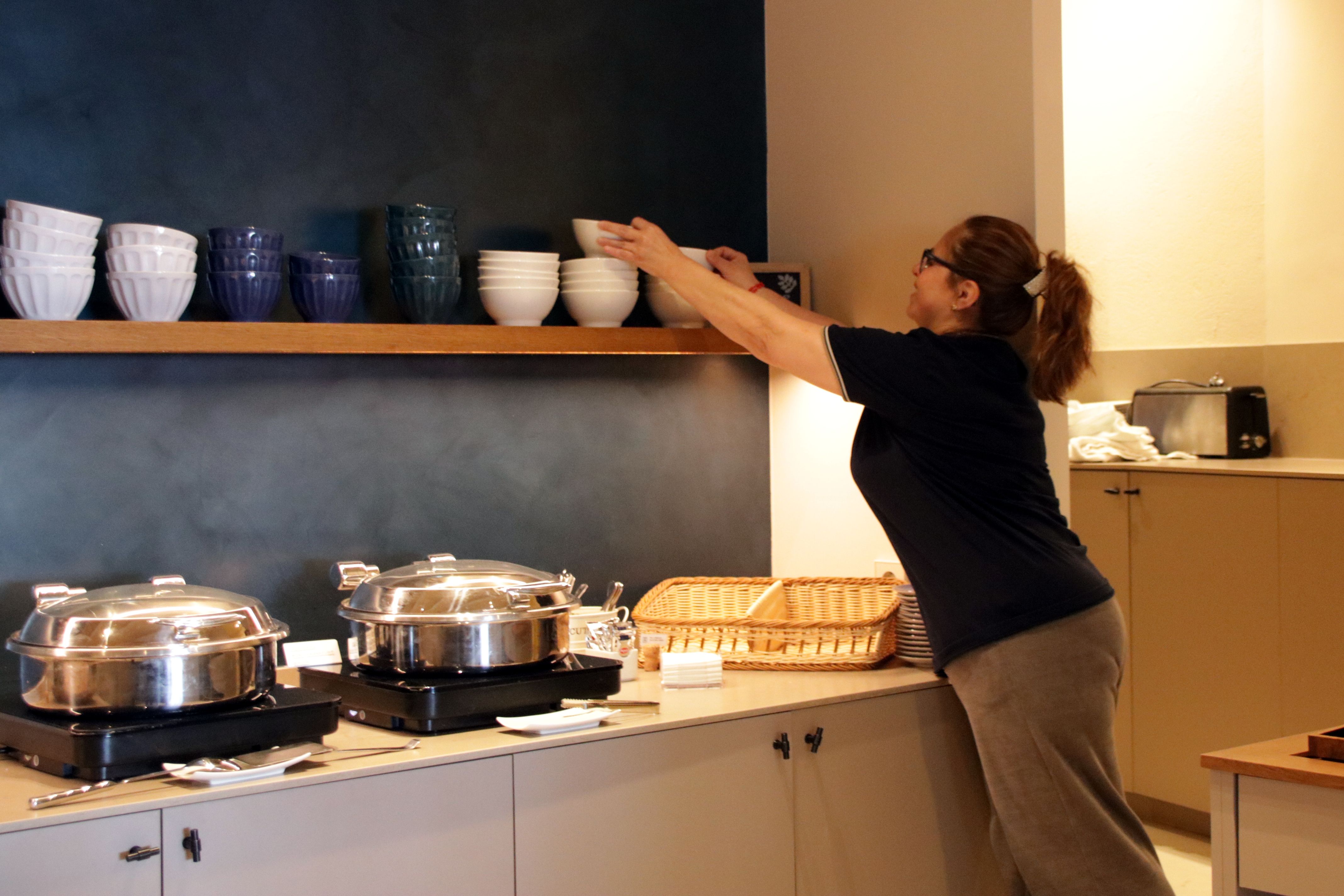Una treballadora col·locant plats en un hotel de Llafranc | Berta Artigas (ACN) Una treballadora col·locant plats en un hotel de Llafranc | Berta Artigas (ACN)