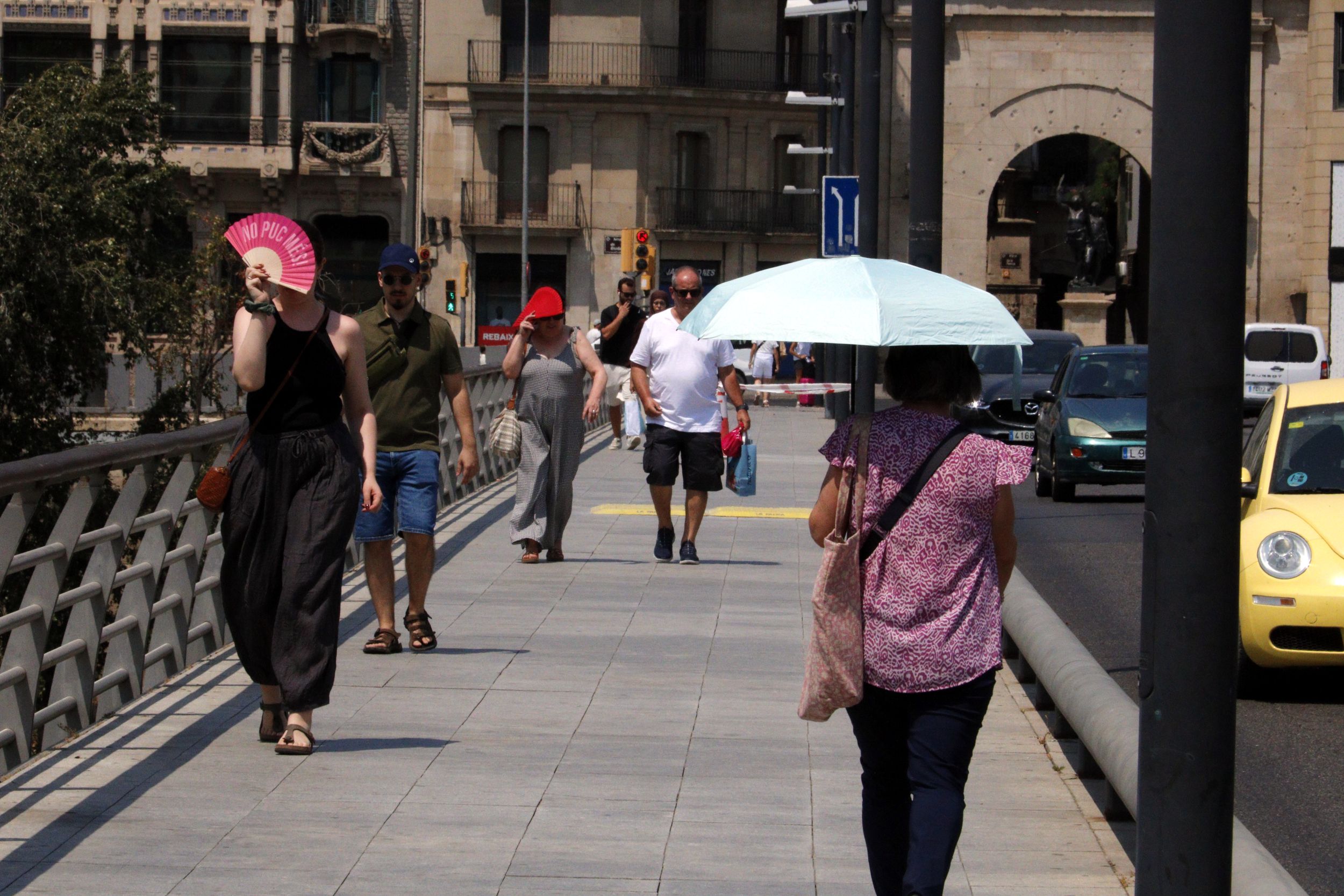Vianants que caminen pel pont Vell de la ciutat de Lleida es protegeixen del sol amb paraigües, gorres i ventalls | Roger Segura (ACN) Vianants que caminen pel pont Vell de la ciutat de Lleida es protegeixen del sol amb paraigües, gorres i ventalls | Roger Segura (ACN)
