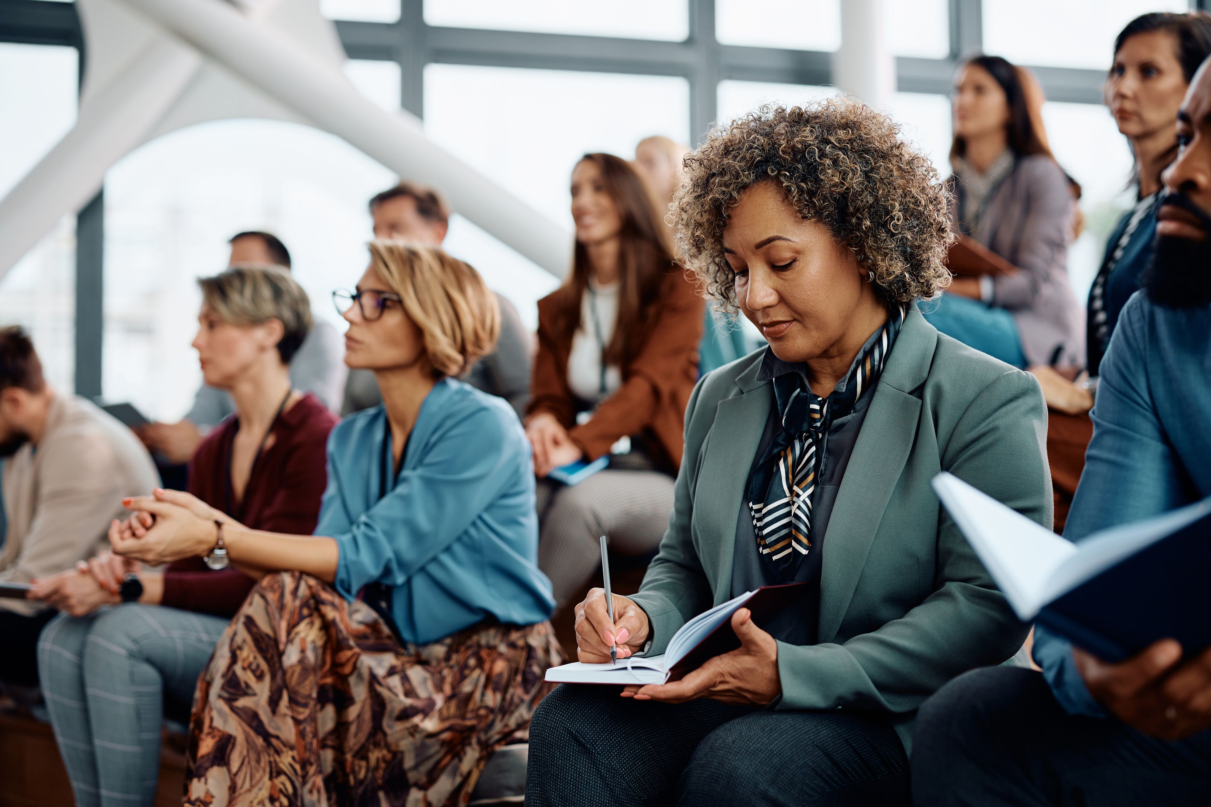 Diversos trabajadores asisten a una conferencia | iStock