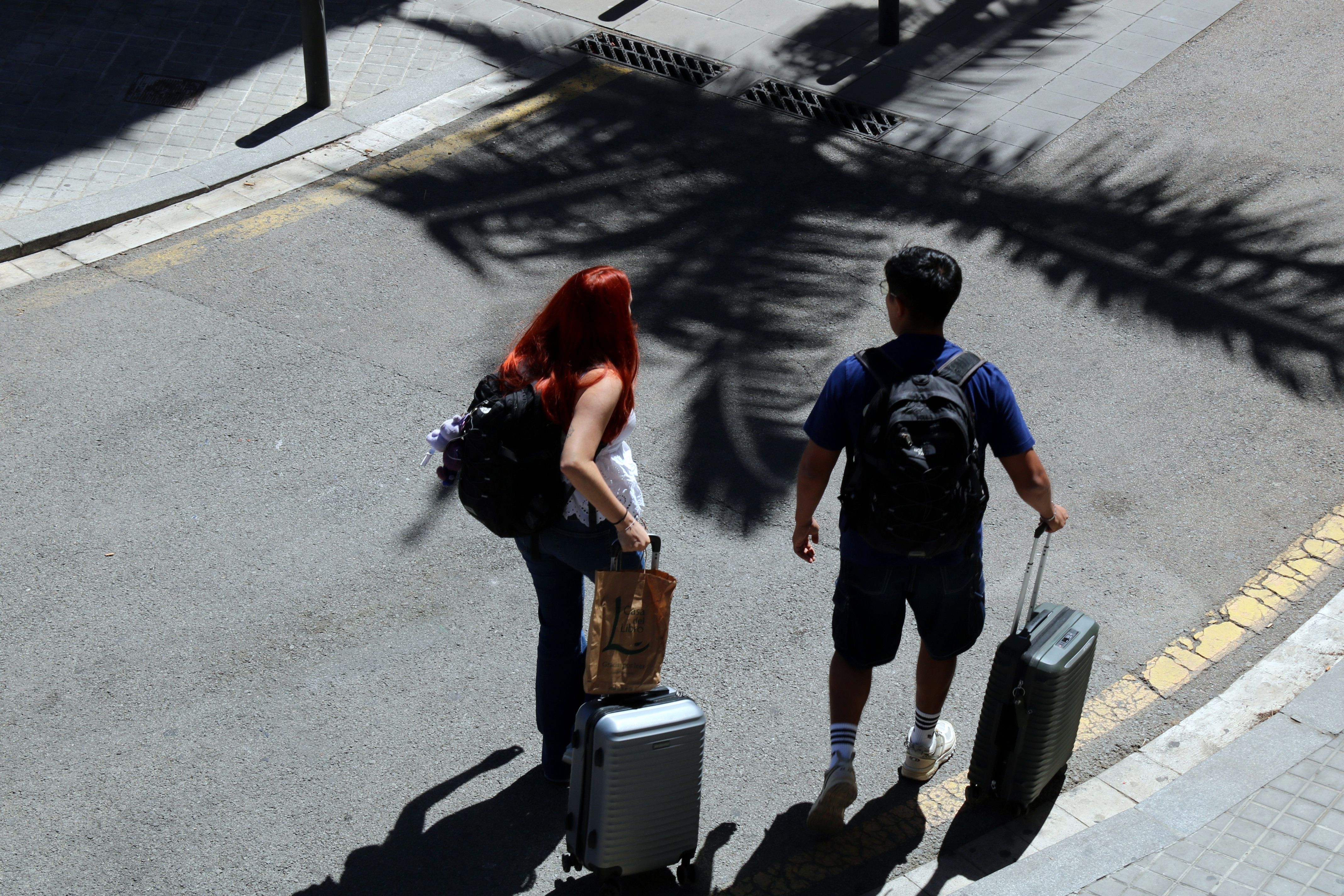 Dos turistes amb maletes per Barcelona | Andrea Salazar (ACN)