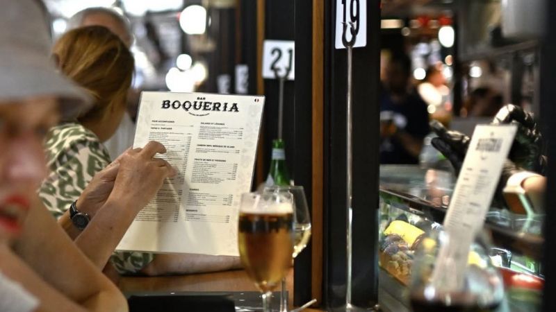 Un visitant consulta la carta d'una de les parades del mercat | Mercat de la Boqueria Un visitant consulta la carta d'una de les parades del mercat | Mercat de la Boqueria