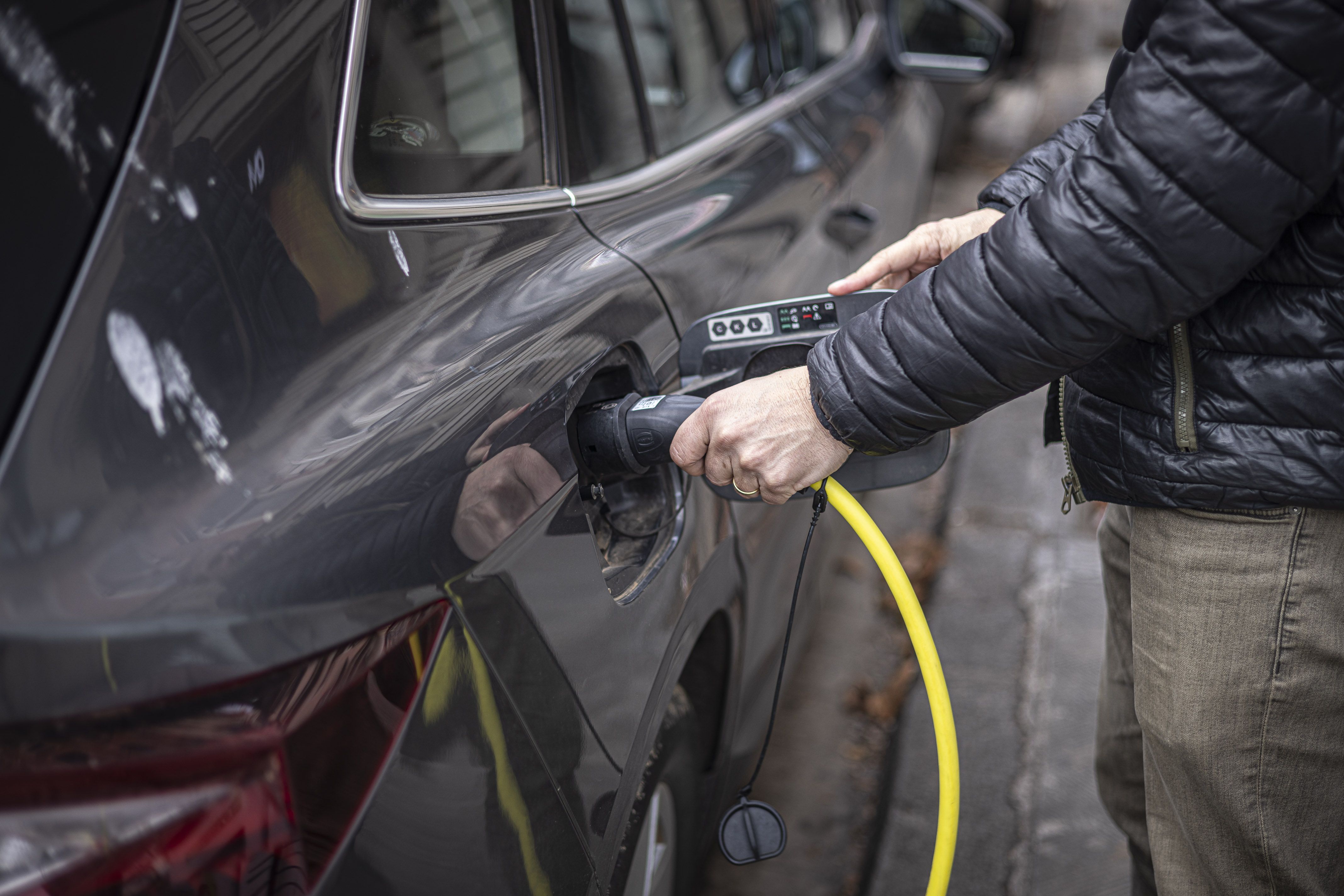 Una persona cargando un coche eléctrico | Jordi Borràs (ACN)