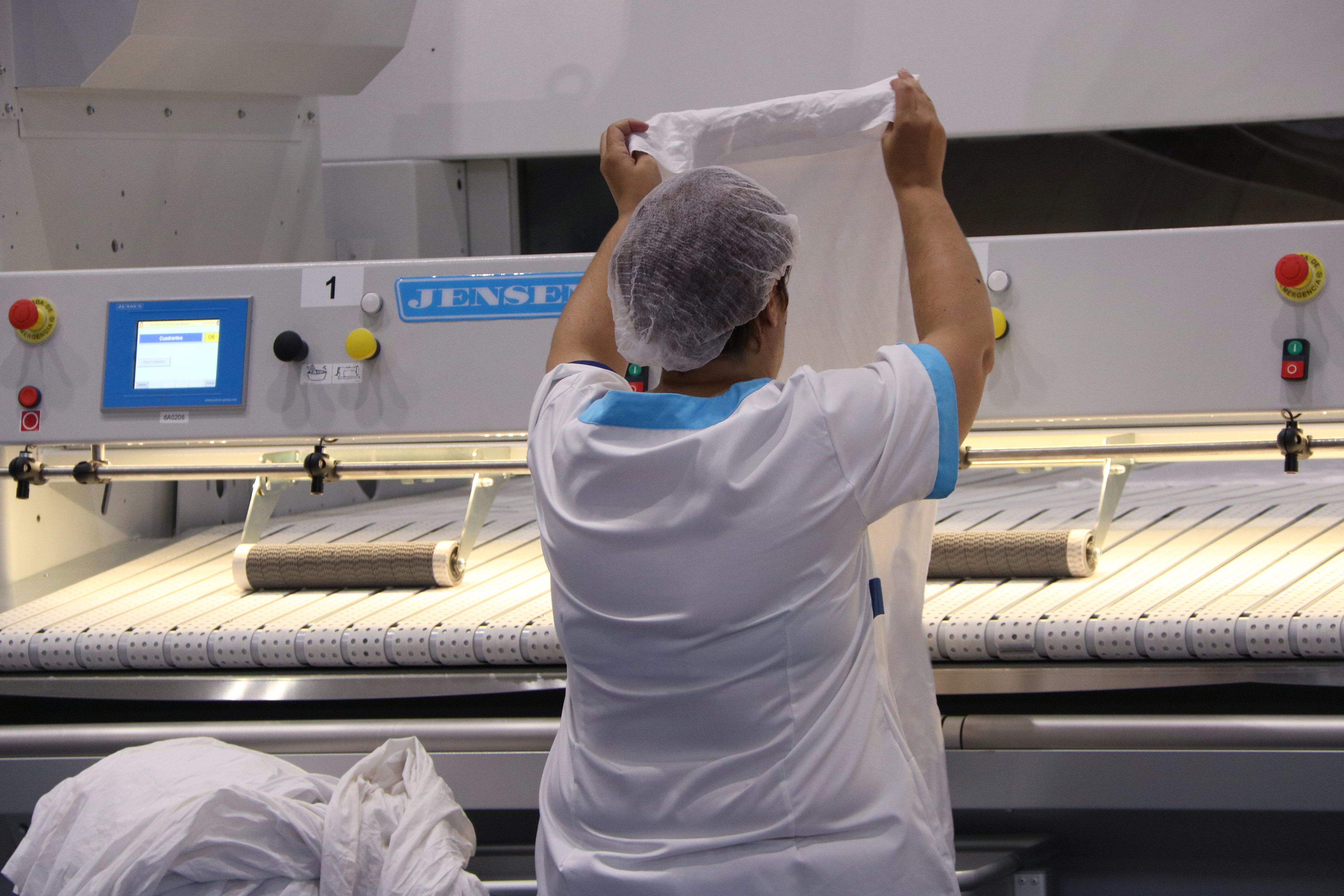 Una treballadora a la bugaderia industrial d'Elis a la Zona Franca | ACN